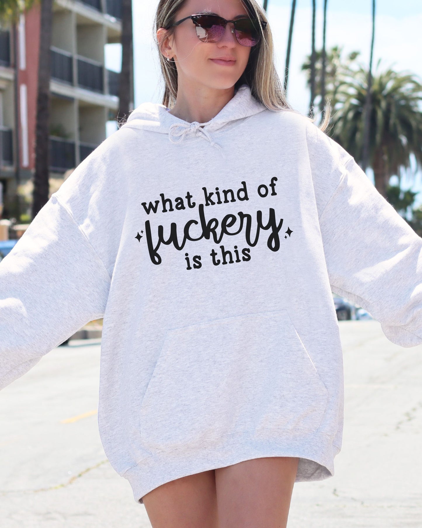 Person wearing a white hoodie with text in an urban setting
