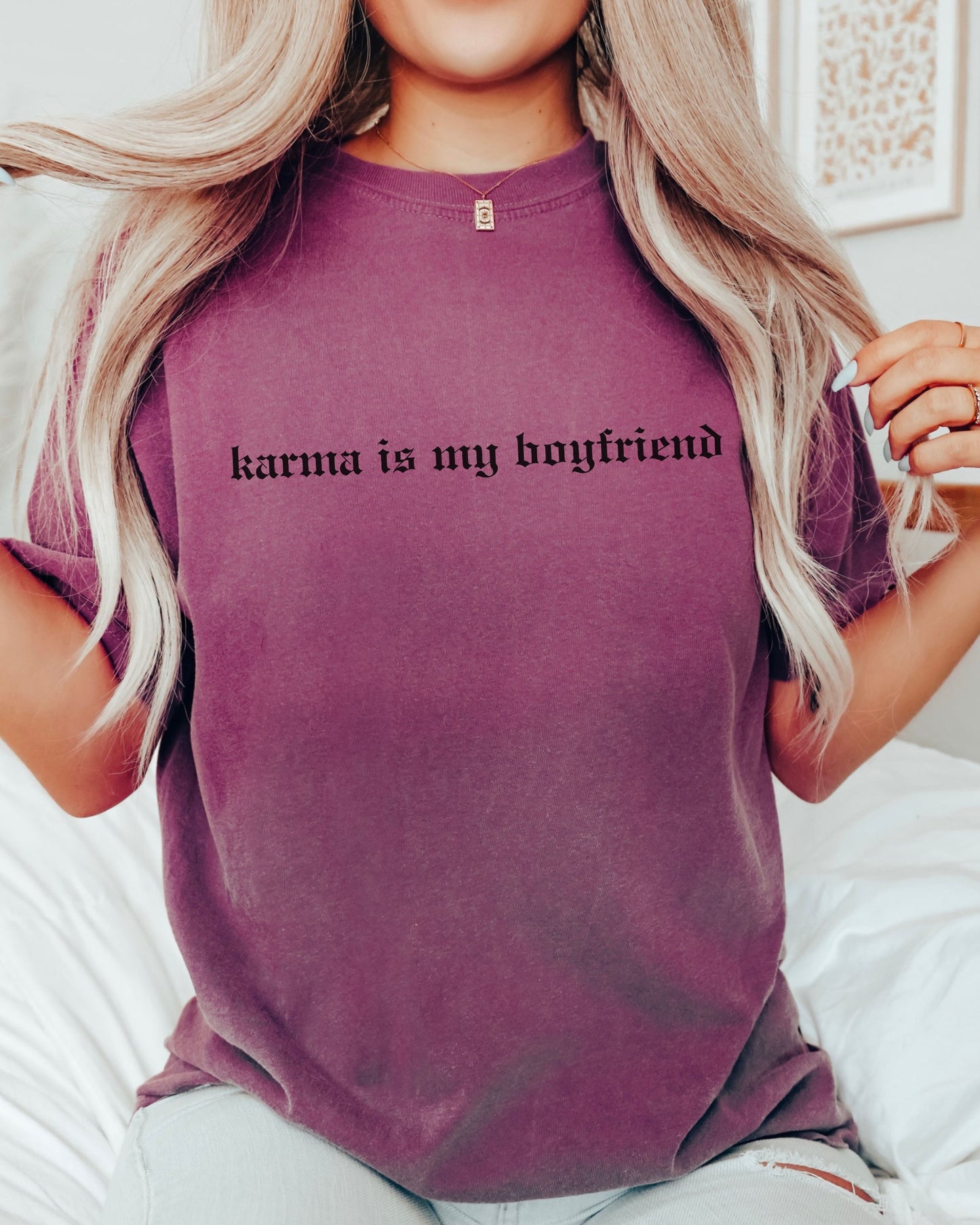Person wearing a purple t-shirt with 'karma is my boyfriend' text.