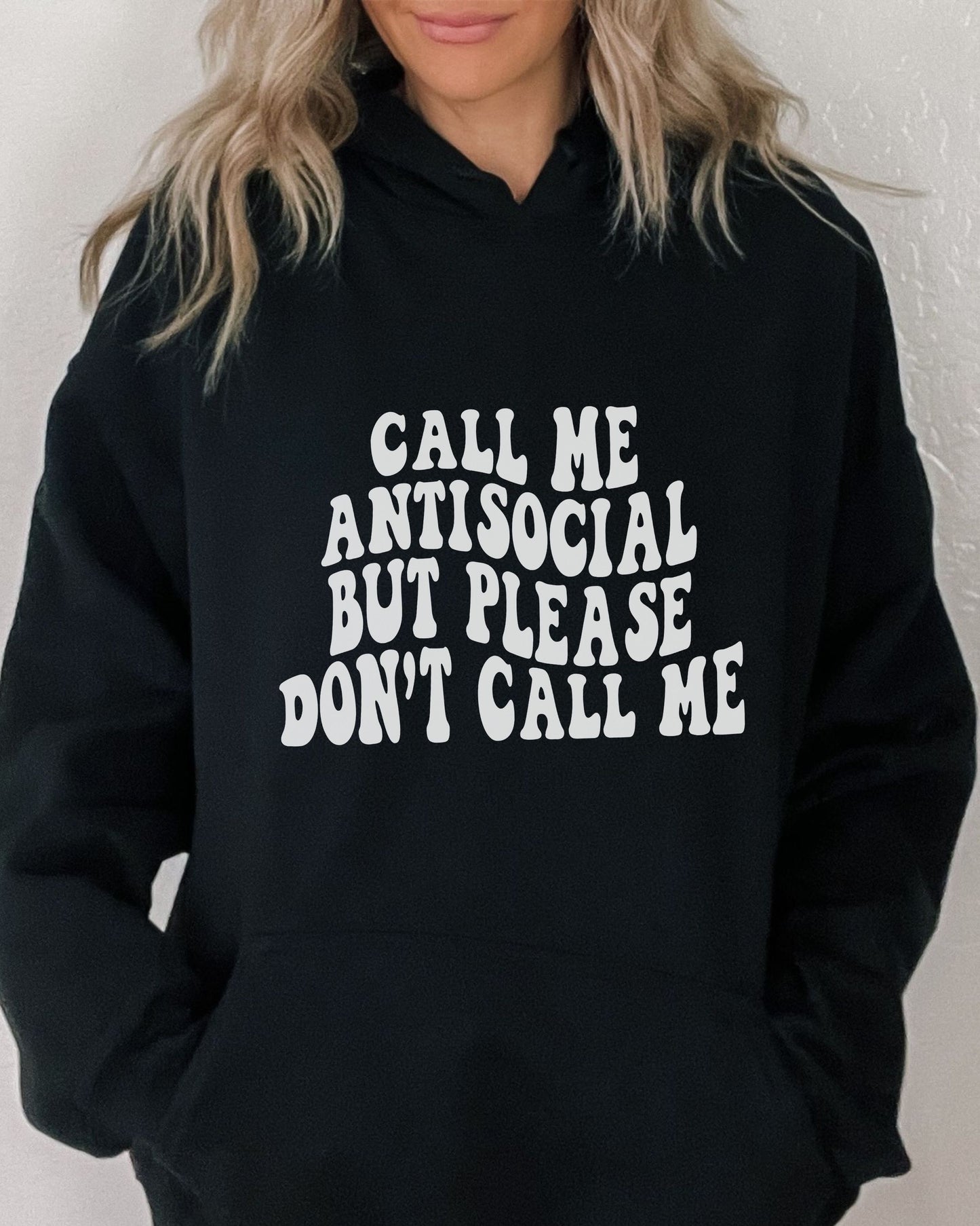 Person wearing a black hoodie with white text on a plain background