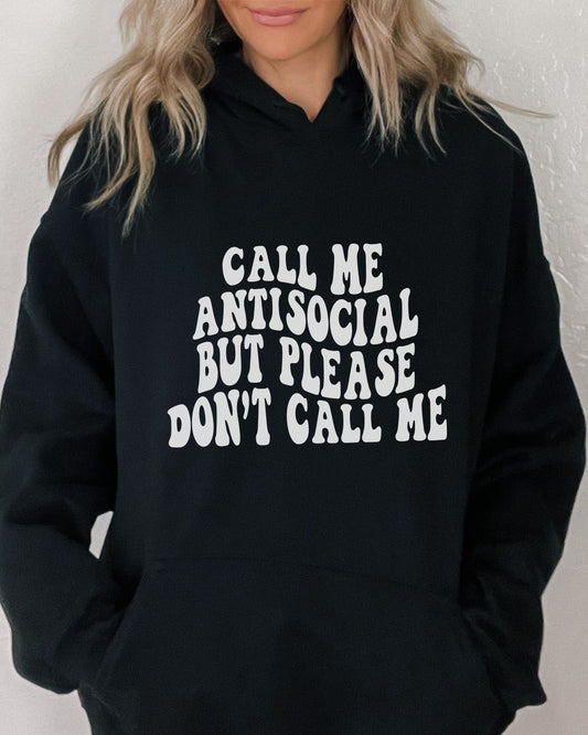 Person wearing a black hoodie with white text on a plain background