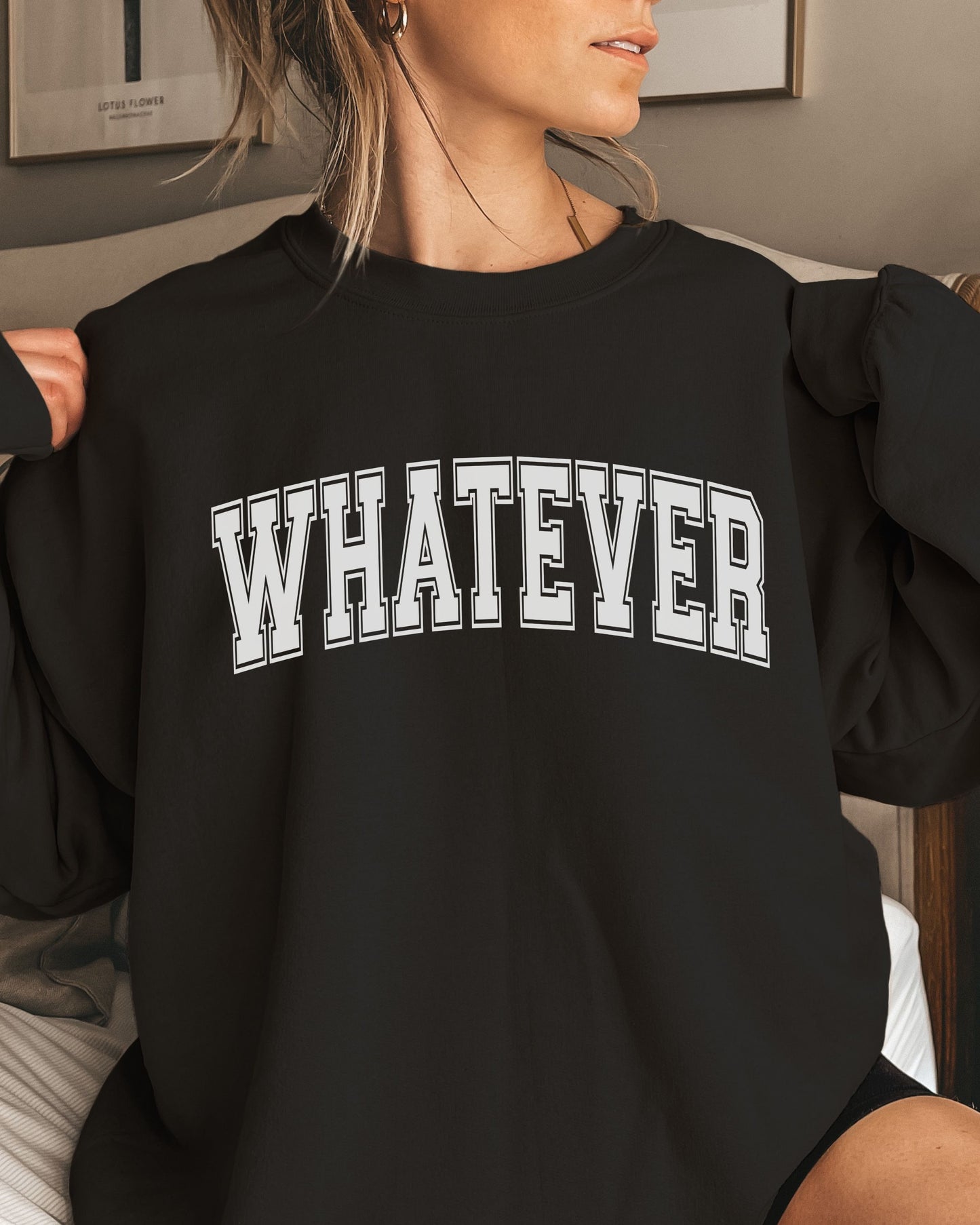 Person wearing a black sweatshirt with 'WHATEVER' text in white.