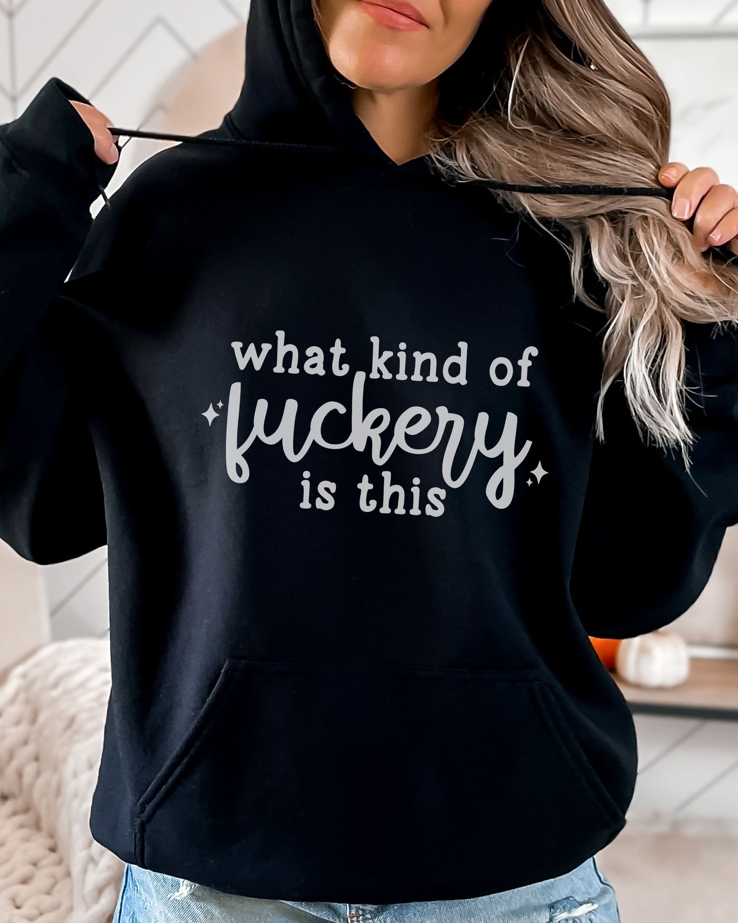Person wearing a black hoodie with text in a casual setting