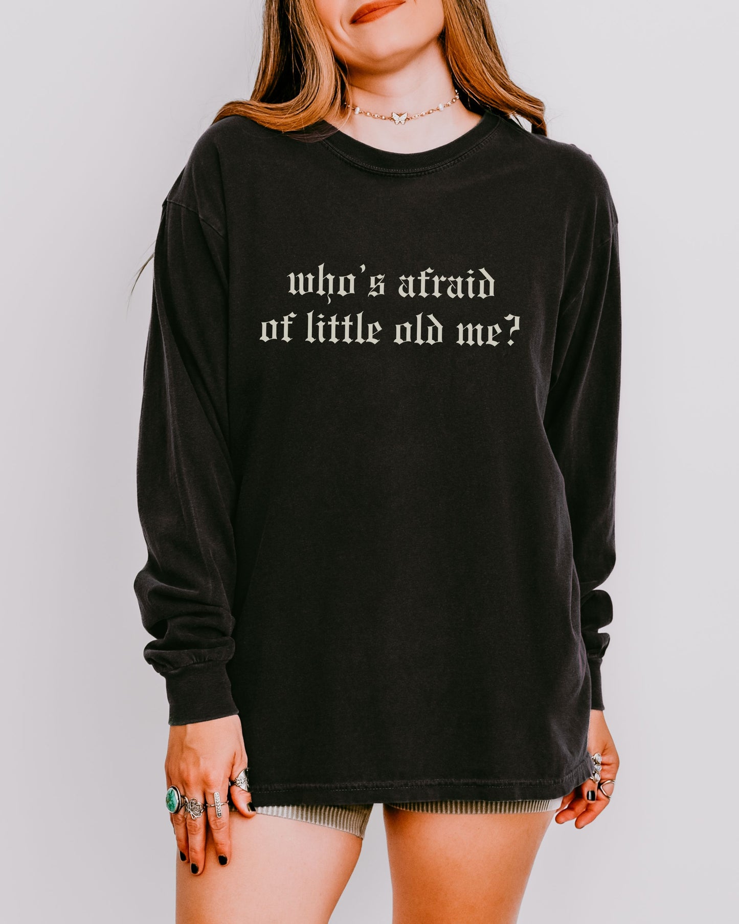 Person wearing a black long-sleeve shirt with text on a plain background