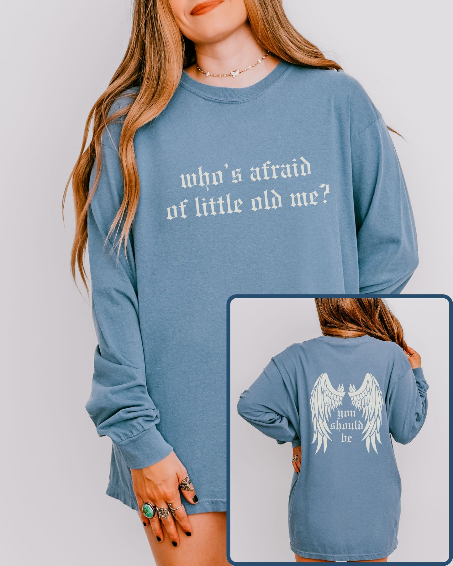 Blue long-sleeve shirt with text and angel wings design on a plain background