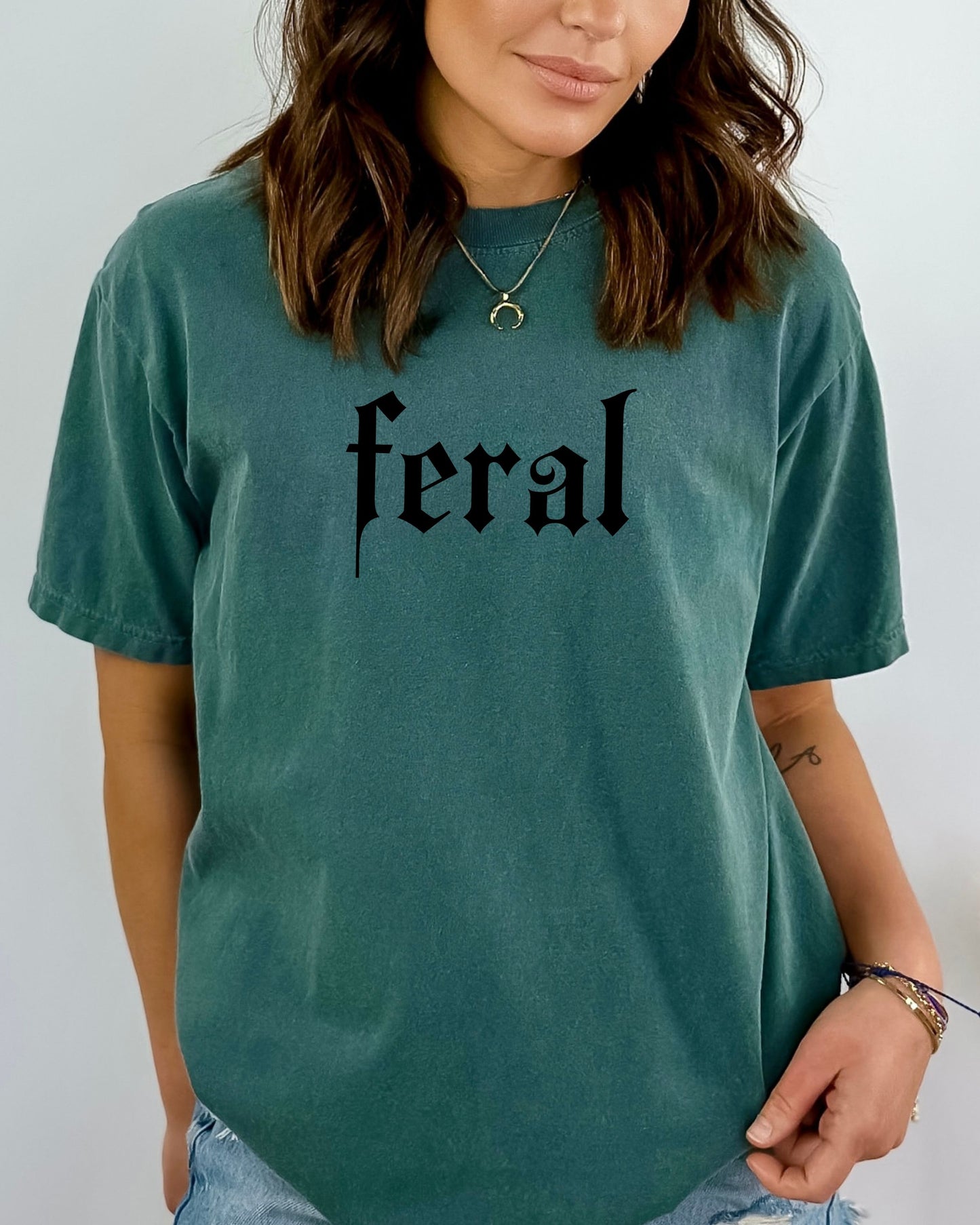grunge aesthetic feral t-shirt in black font worn by model, in color blue spruce