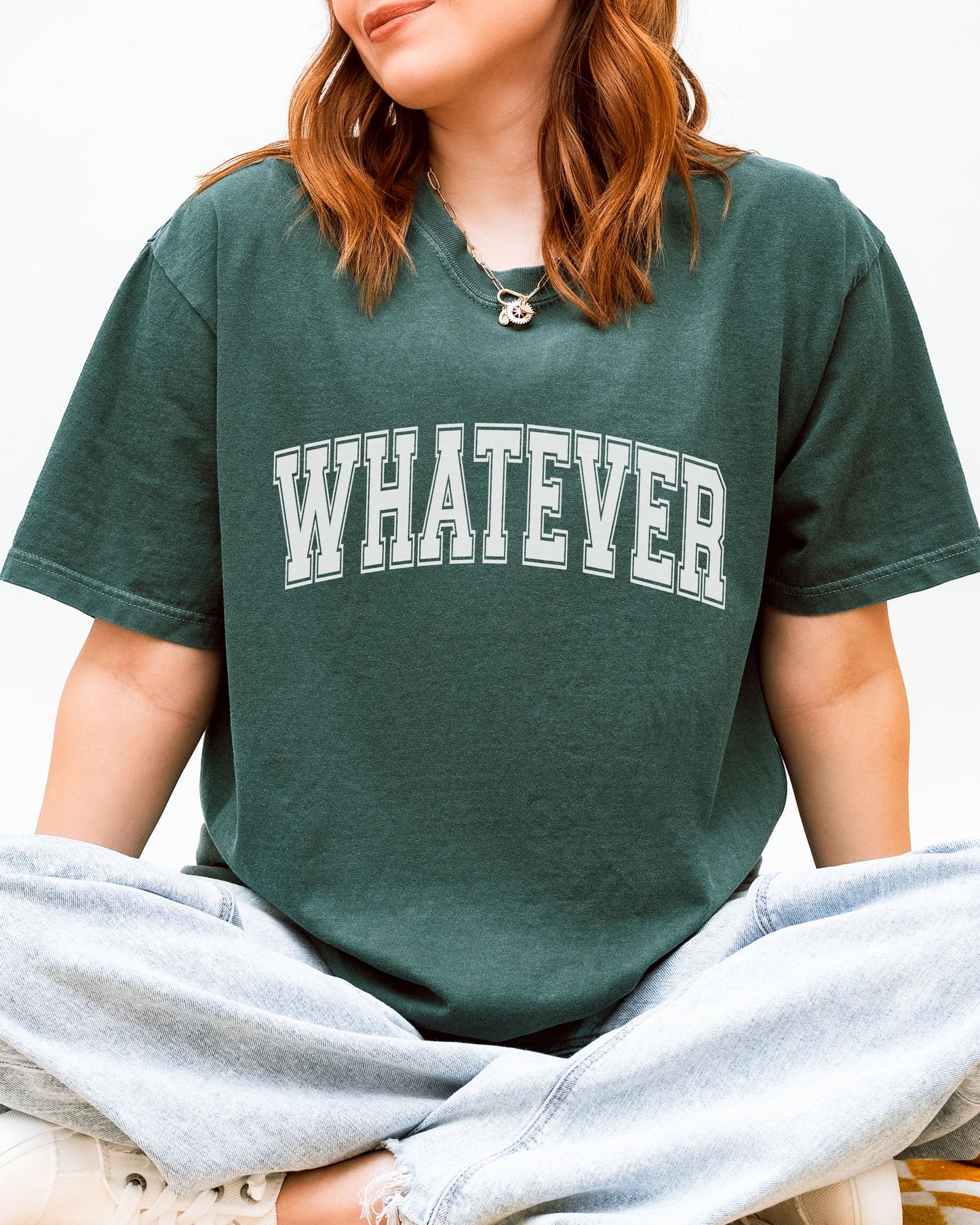 Person wearing a green t-shirt with 'WHATEVER' text on a white background
