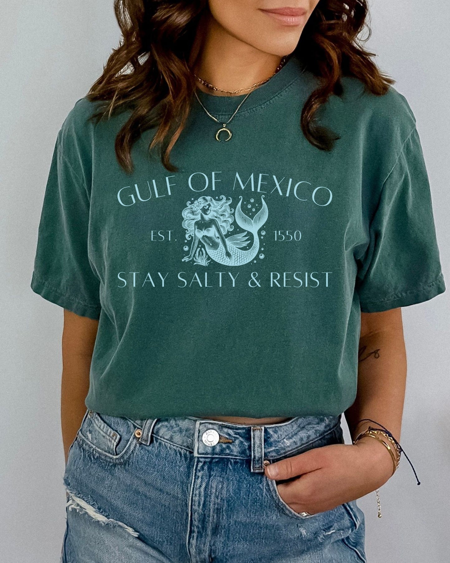 Person wearing a green t-shirt with 'Gulf of Mexico' and 'Stay Salty & Resist' text.