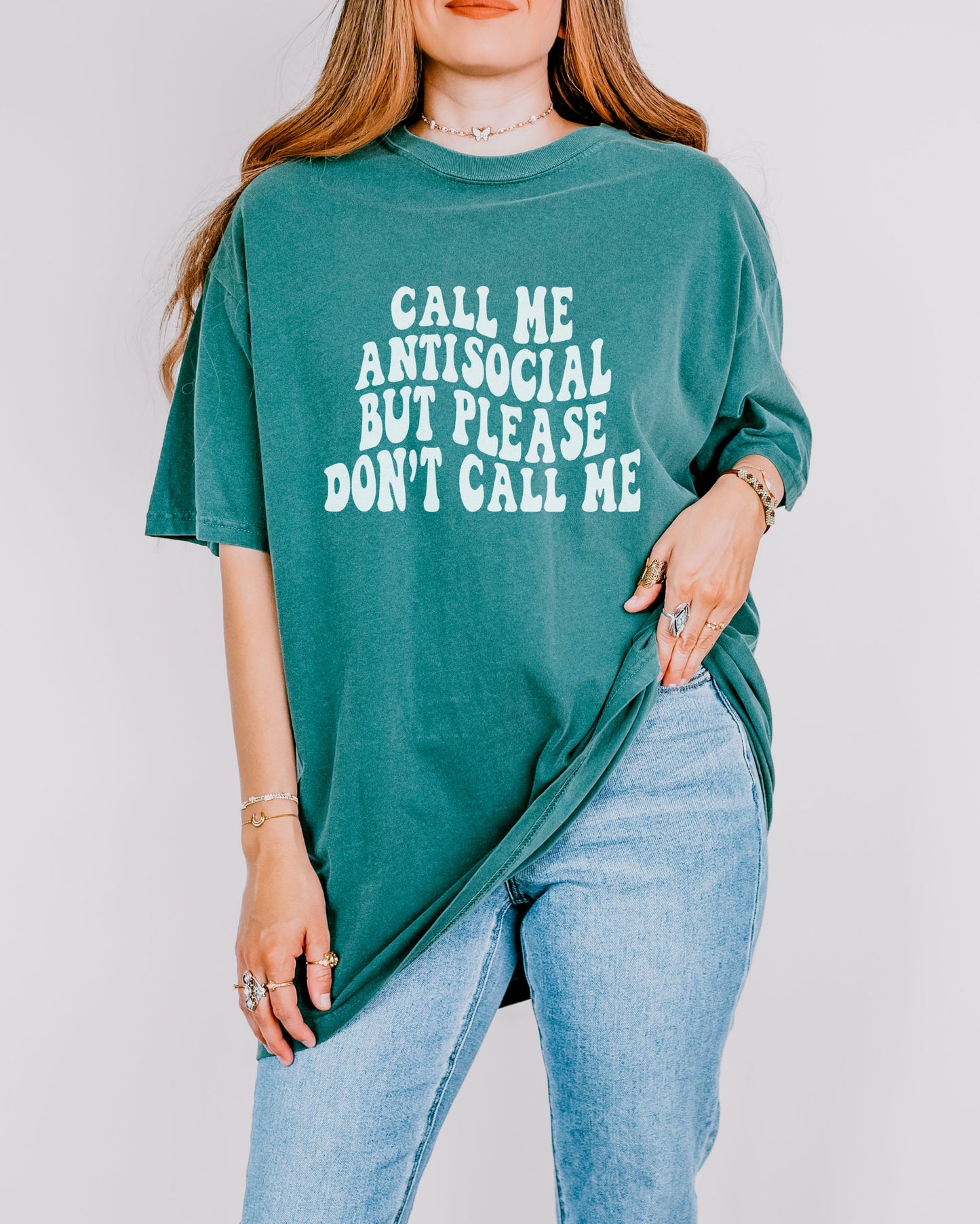 Person wearing a green t-shirt with text, standing against a plain background