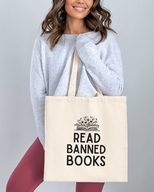 Person holding a tote bag with 'Read Banned Books' text and design.