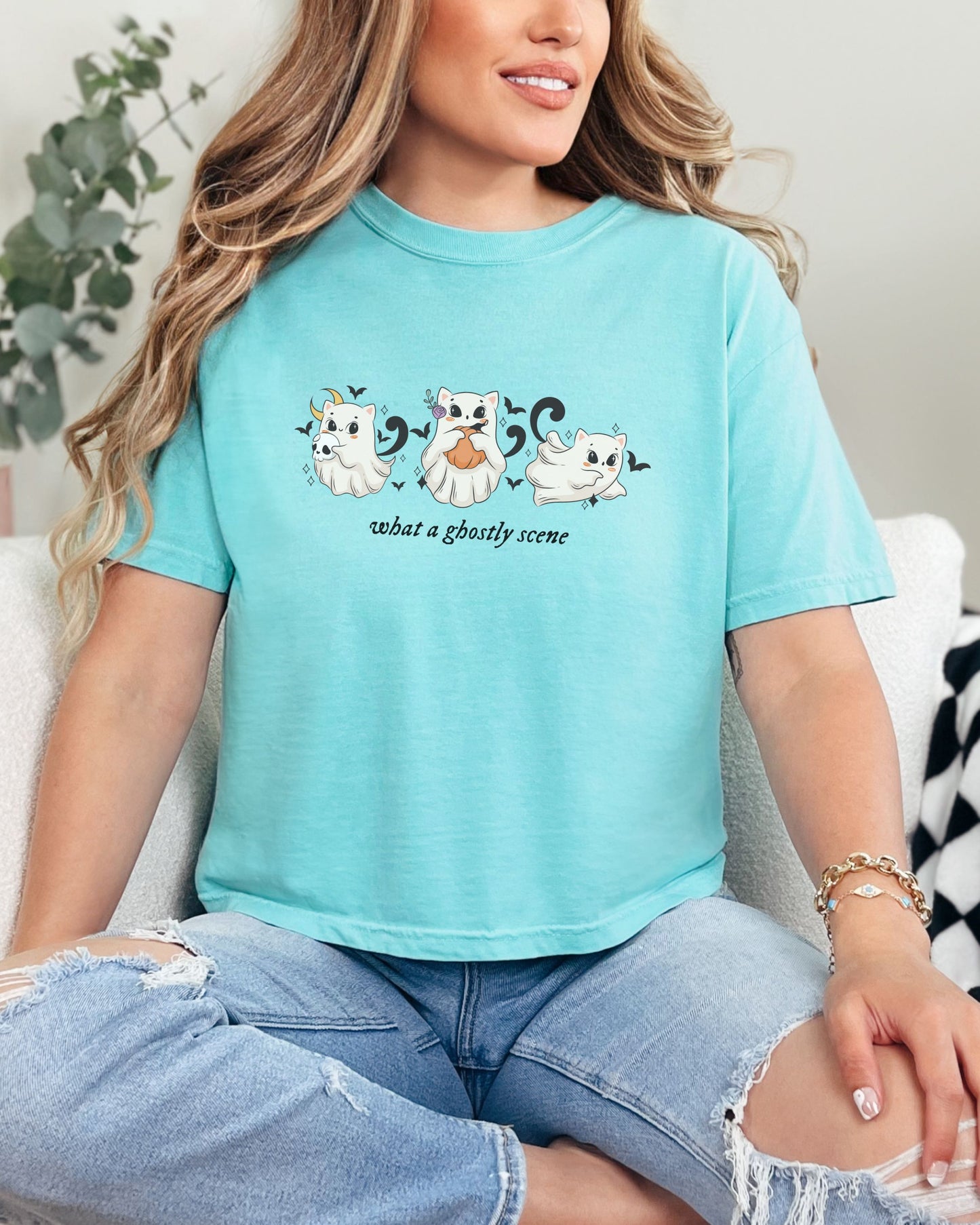 Person wearing a light blue t-shirt with ghost designs and text.