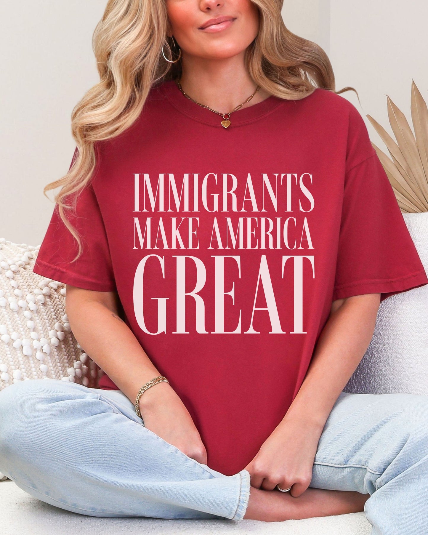 Person wearing a red t-shirt with 'IMMIGRANTS MAKE AMERICA GREAT' text.