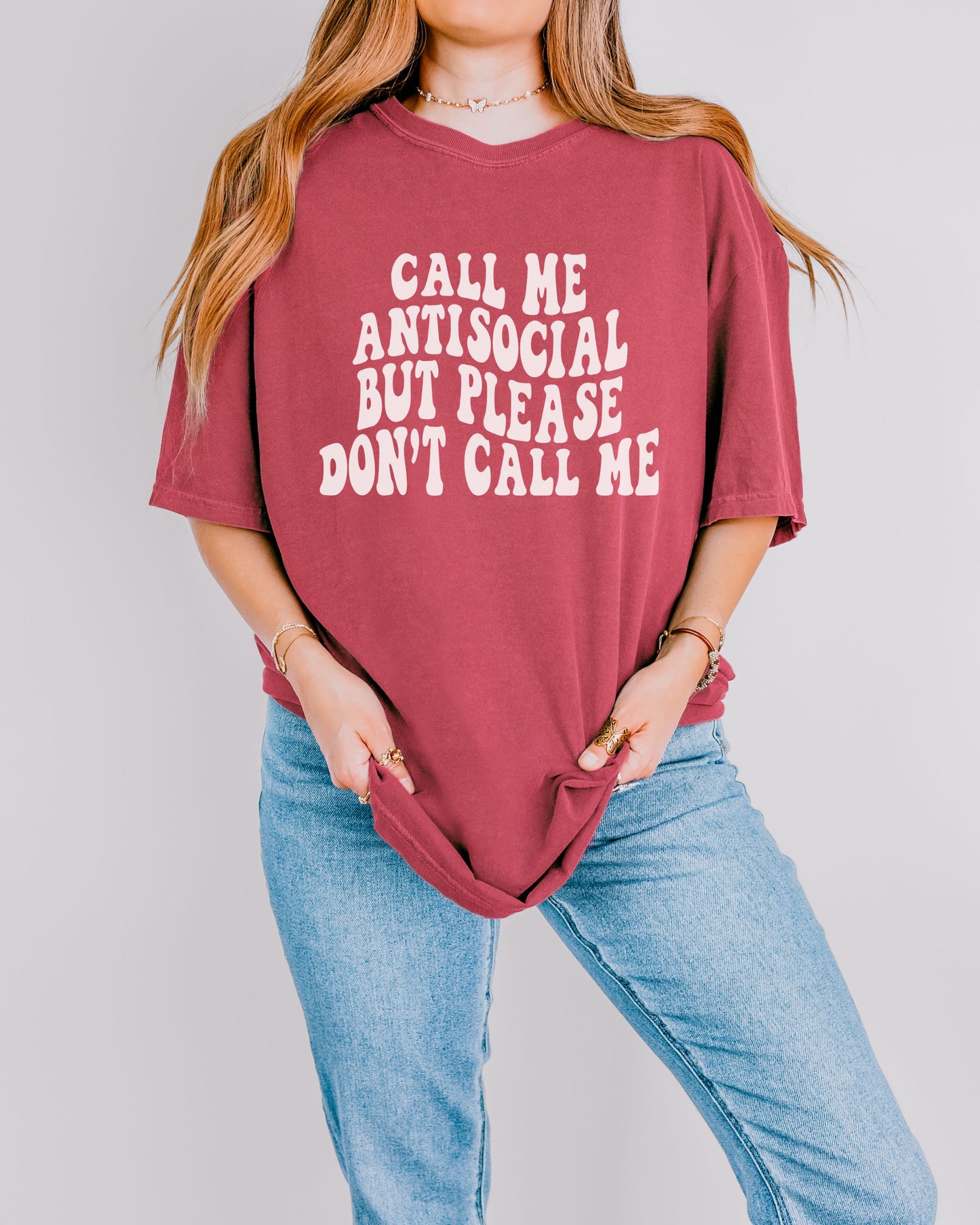 Person wearing a maroon t-shirt with white text on a plain background