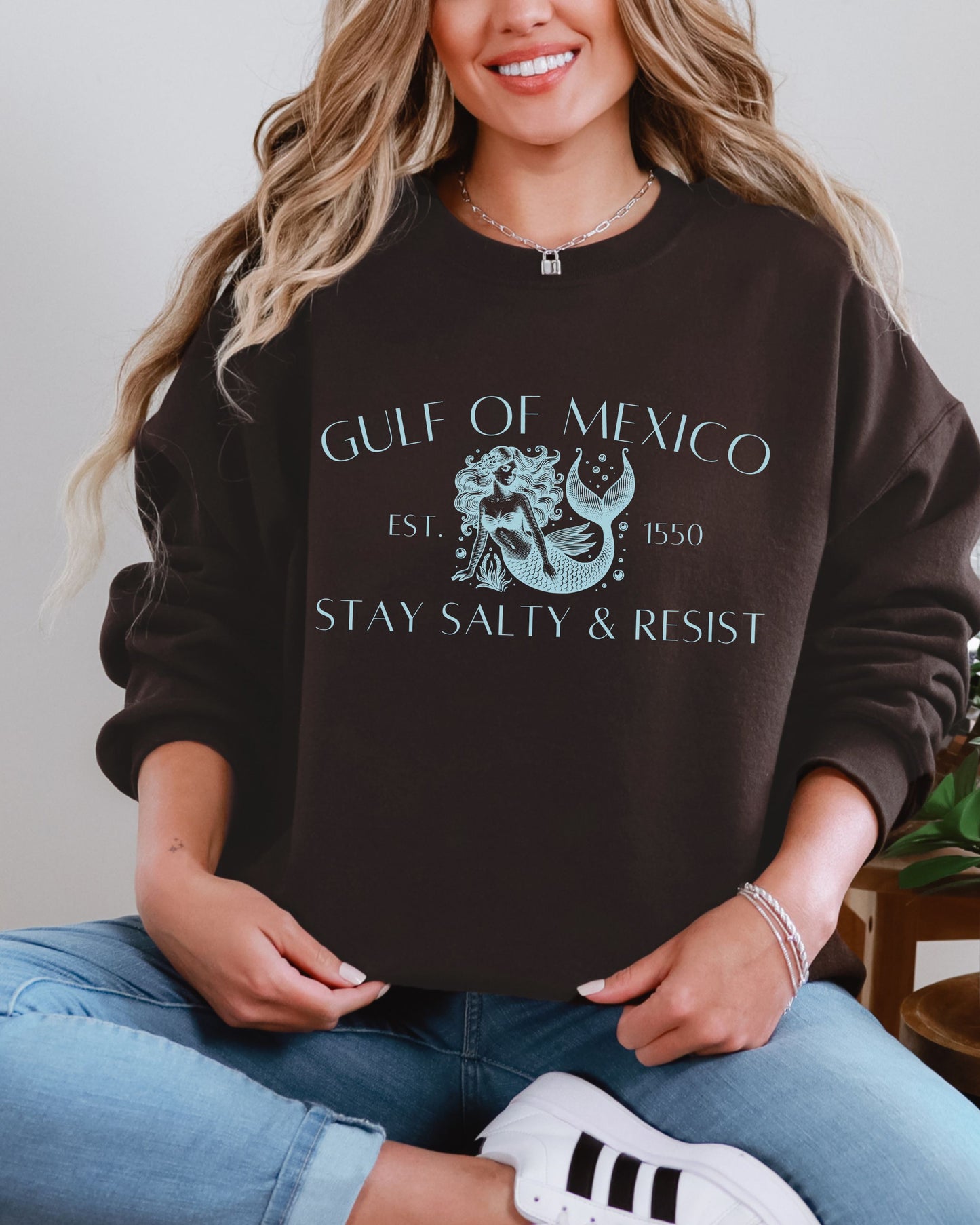 Person wearing a black sweatshirt with 'Gulf of Mexico' and 'Stay Salty & Resist' text.