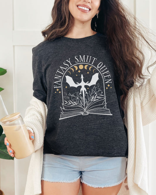 Woman wearing a dark gray t-shirt with 'Fantasy Smut Queen' design, holding a drink.