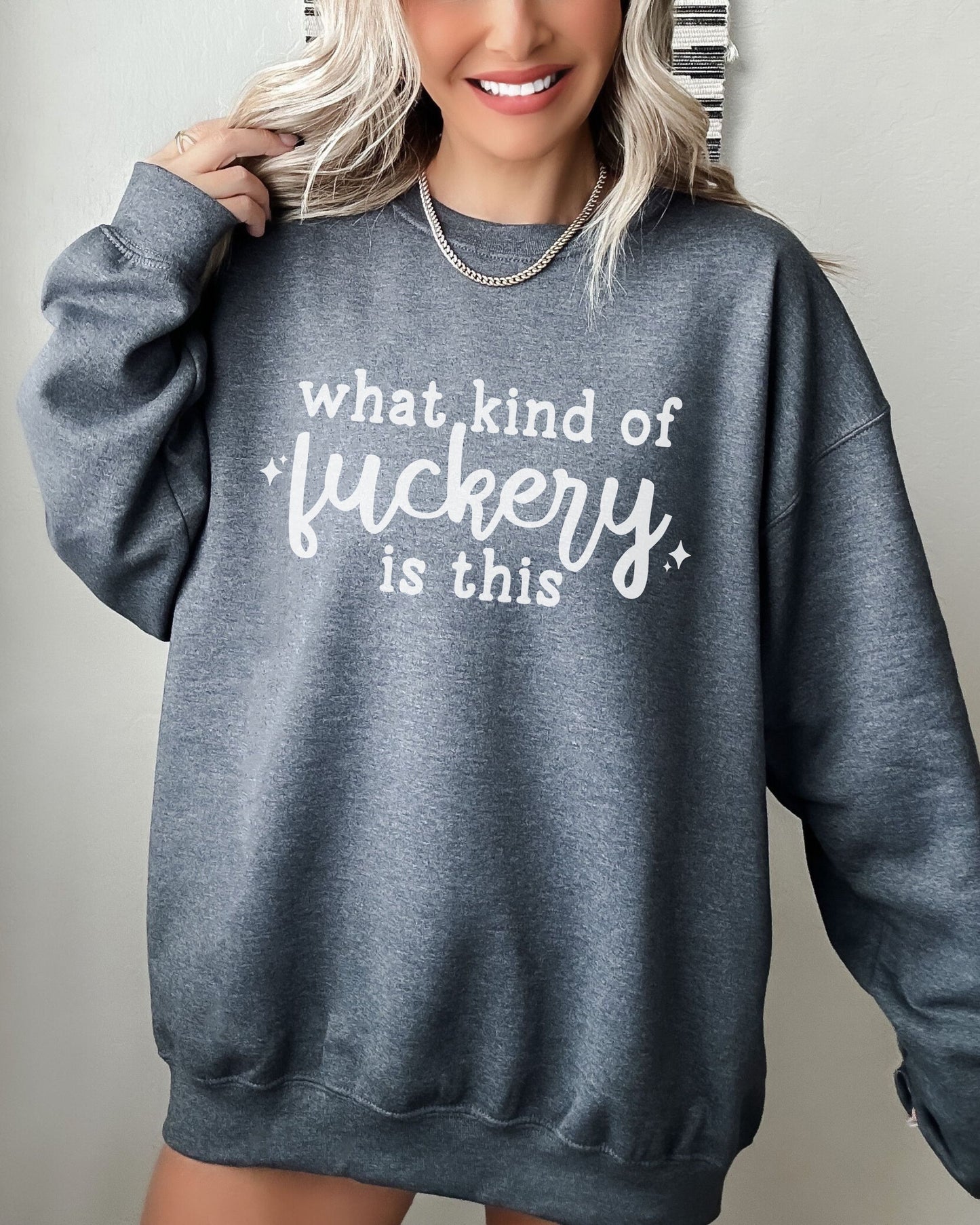 Person wearing a gray sweatshirt with text on a plain background