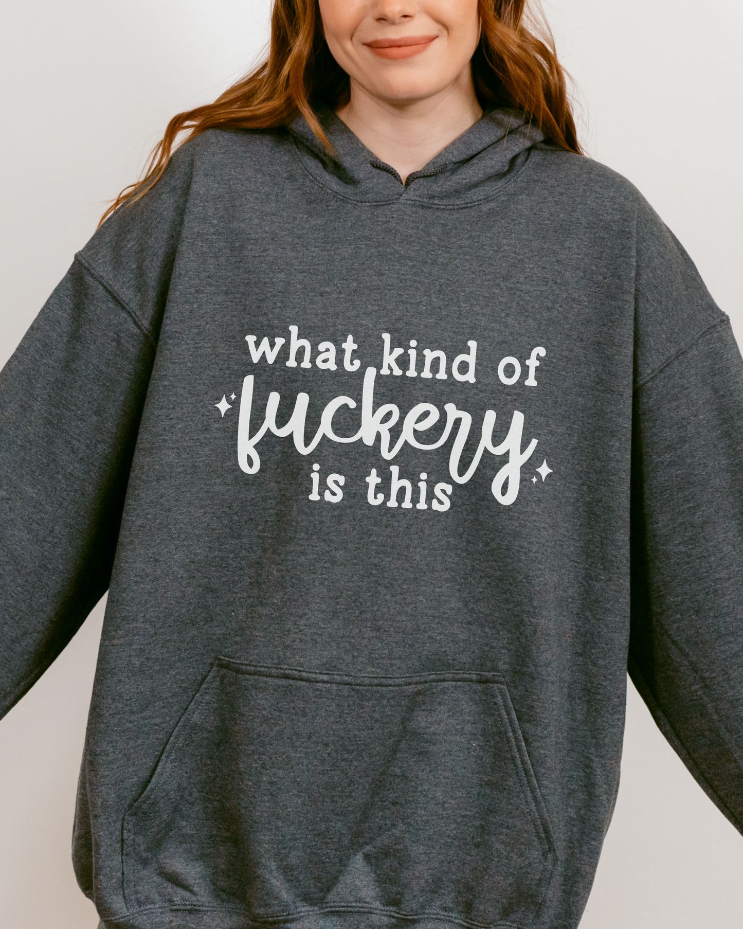 Person wearing a dark gray hoodie with white text on a plain background