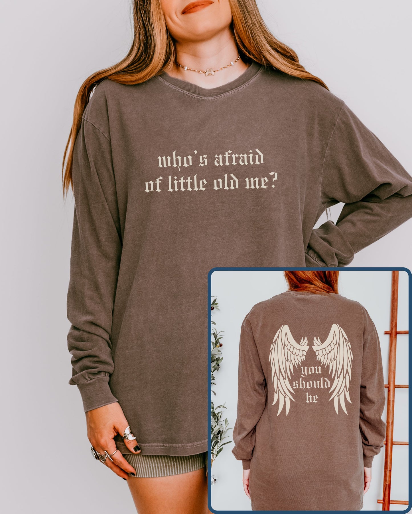 Brown long-sleeve shirt with text and wings graphic, worn by a person.