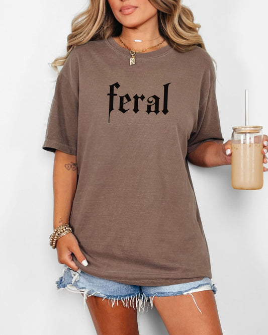 grunge aesthetic feral t-shirt in black font worn by model, in color espresso