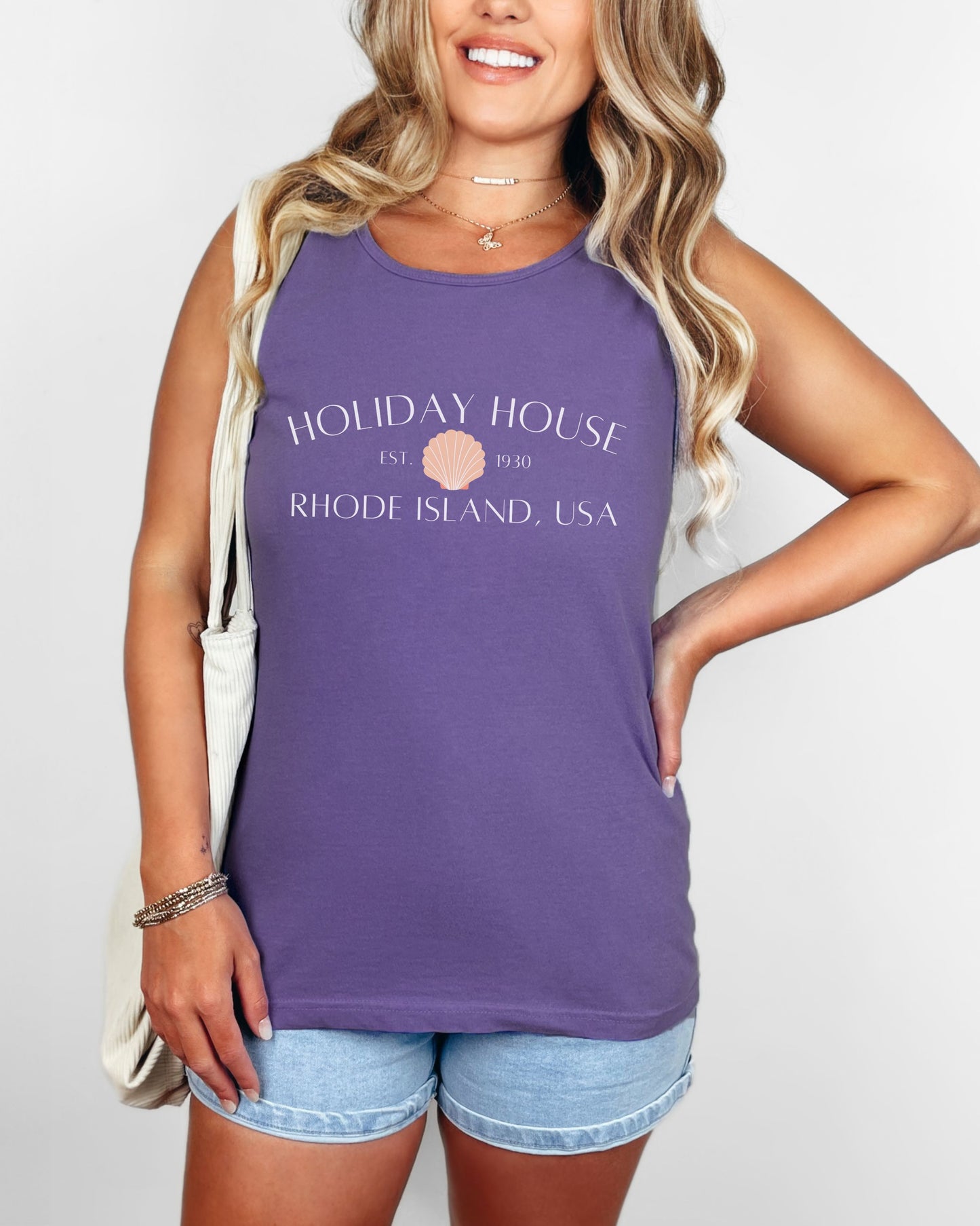Woman wearing a purple tank top with 'Holiday House' text and logo.