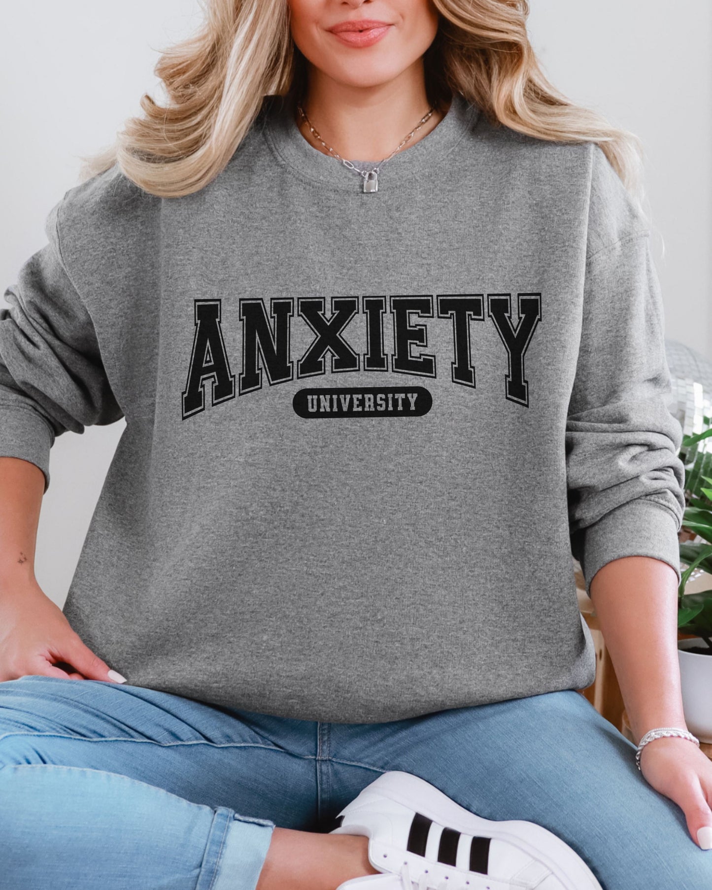 Person wearing a gray sweatshirt with 'ANXIETY UNIVERSITY' text.