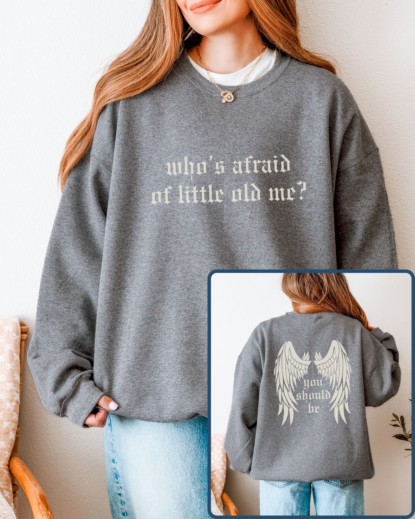 Person wearing a gray sweatshirt with text, with a close-up of the back showing angel wings and additional text.