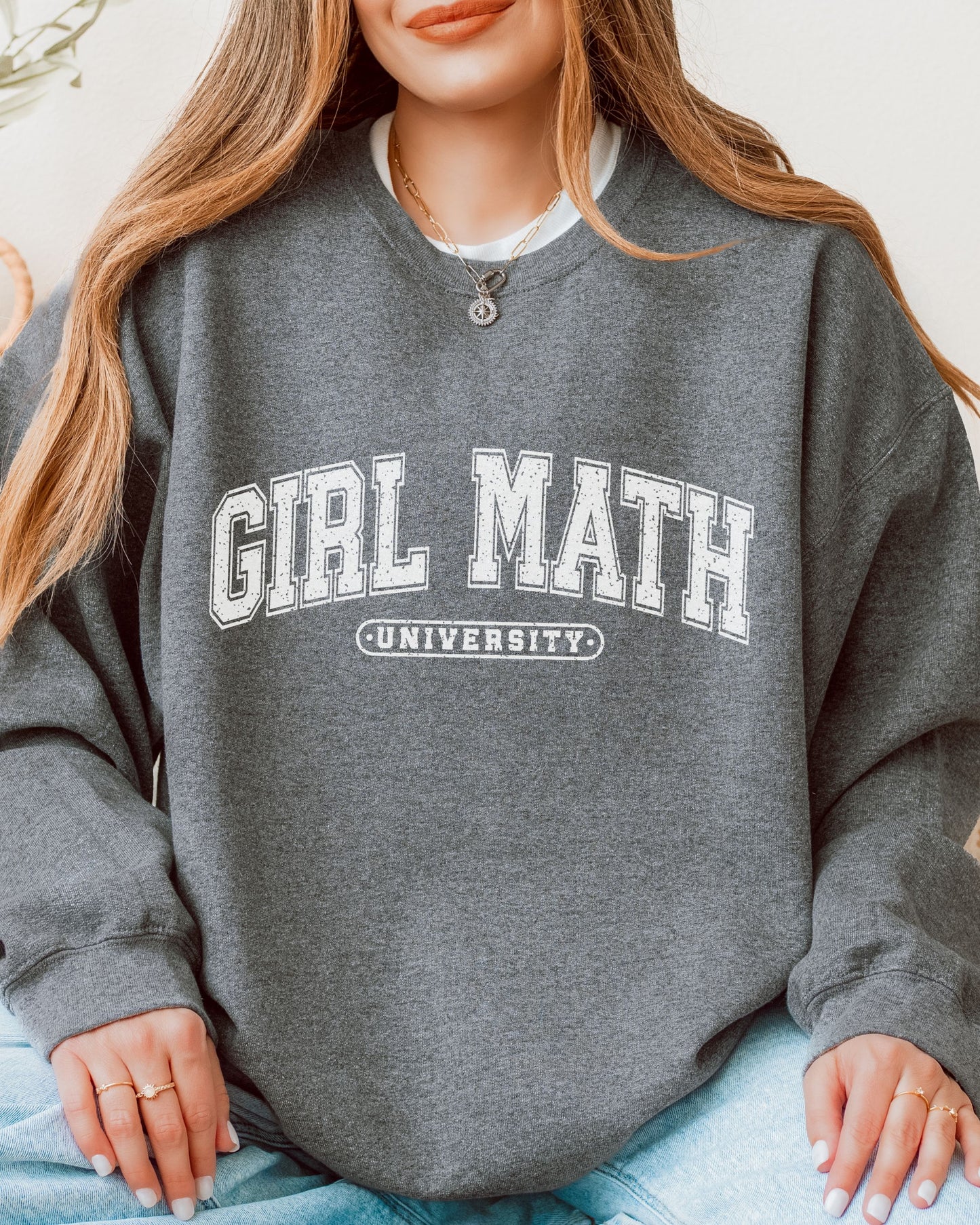 Person wearing a gray sweatshirt with 'Girl Math University' text