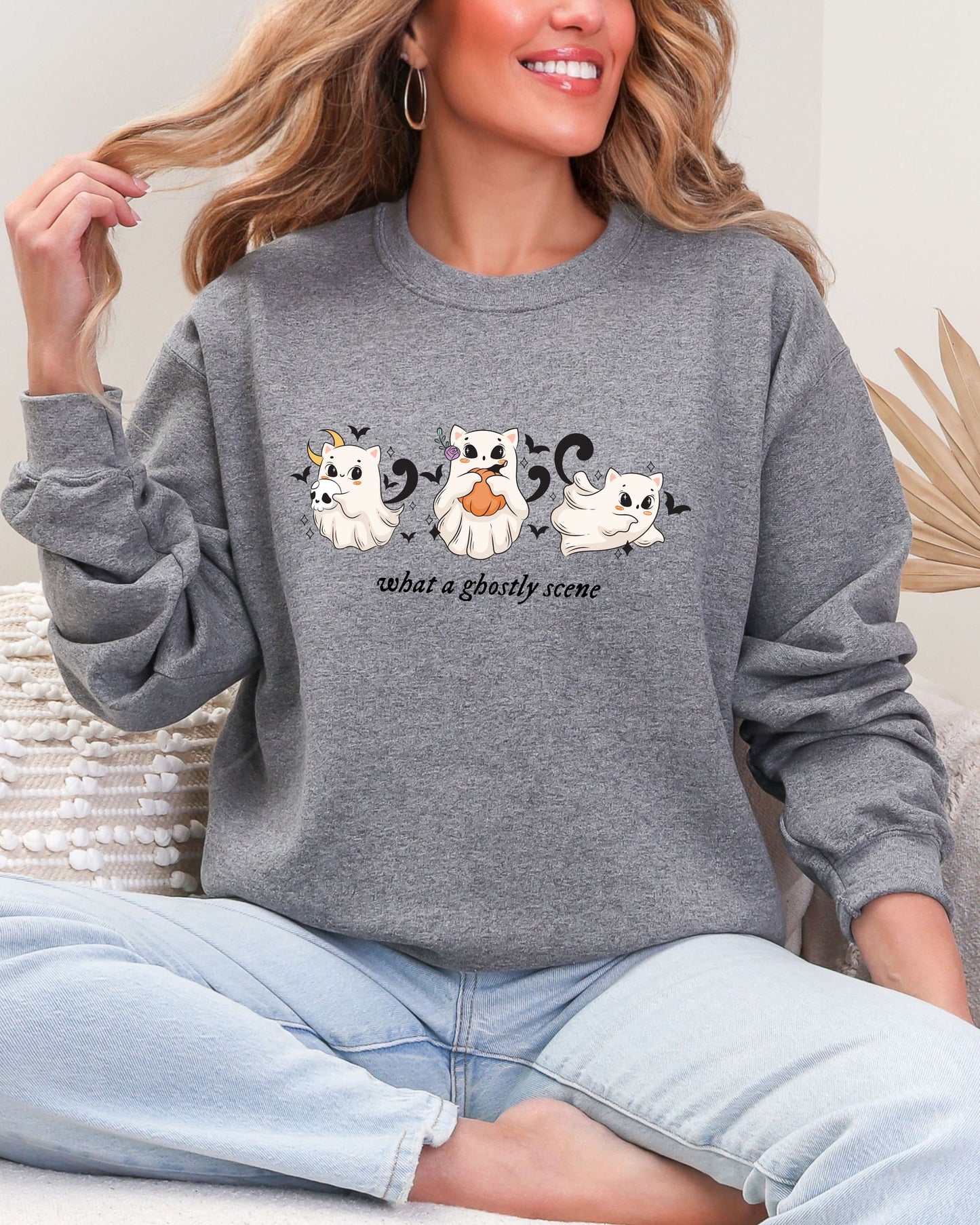 Person wearing a gray sweatshirt with ghost designs and text.
