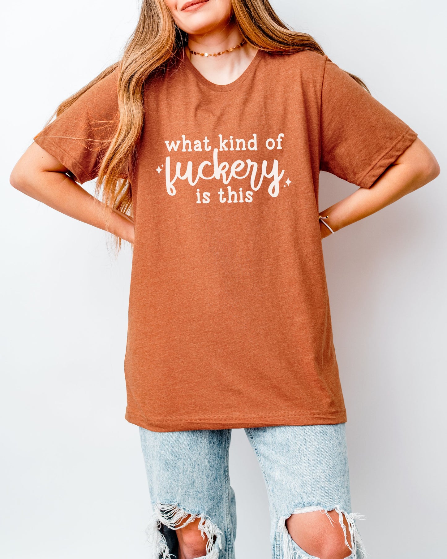 Person wearing an orange t-shirt with text on a plain background
