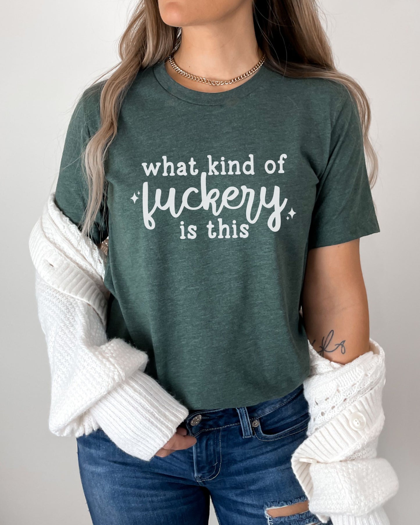 Person wearing a green t-shirt with text, white sweater, and jeans on a plain background