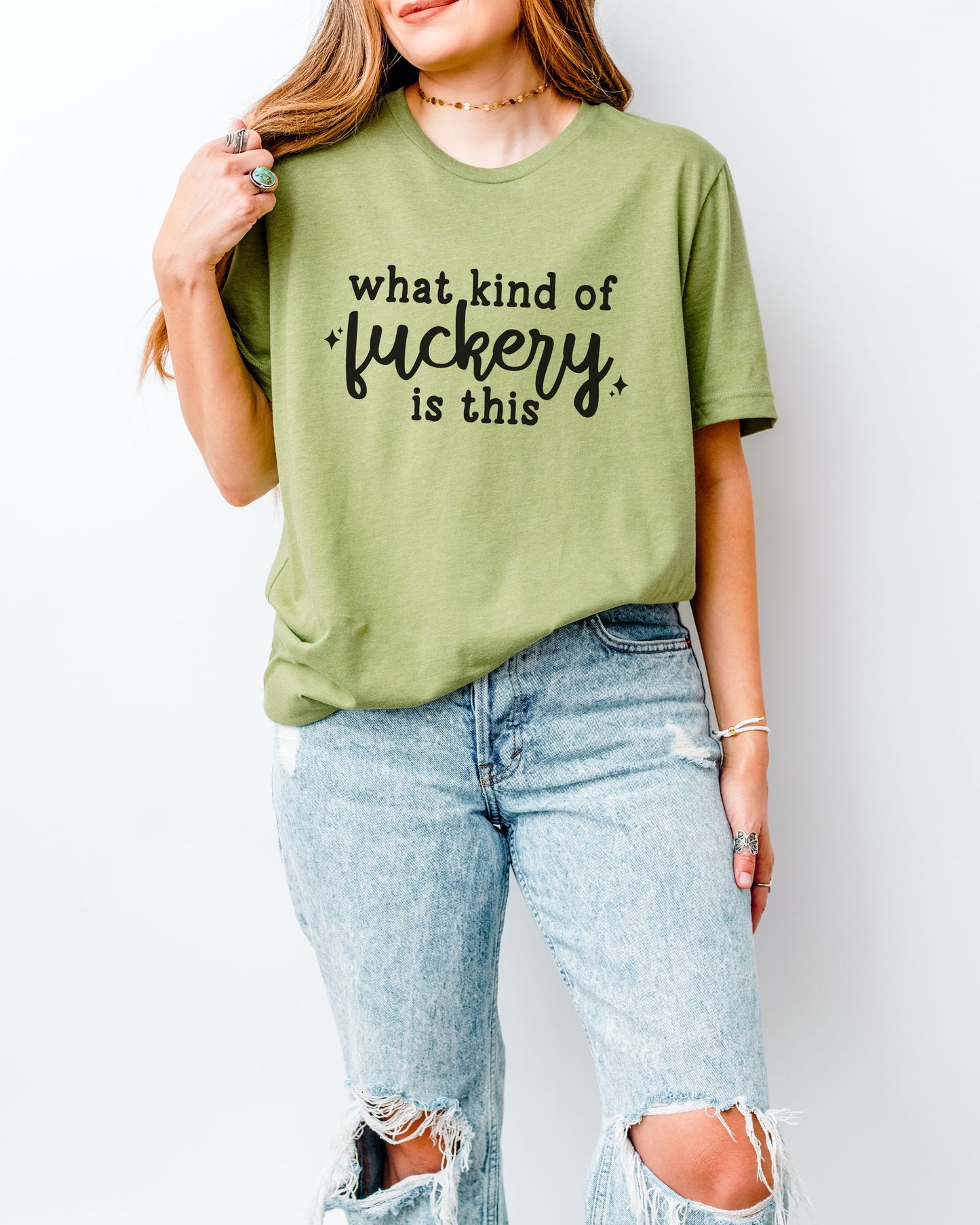 Person wearing a green t-shirt with text and ripped jeans on a white background