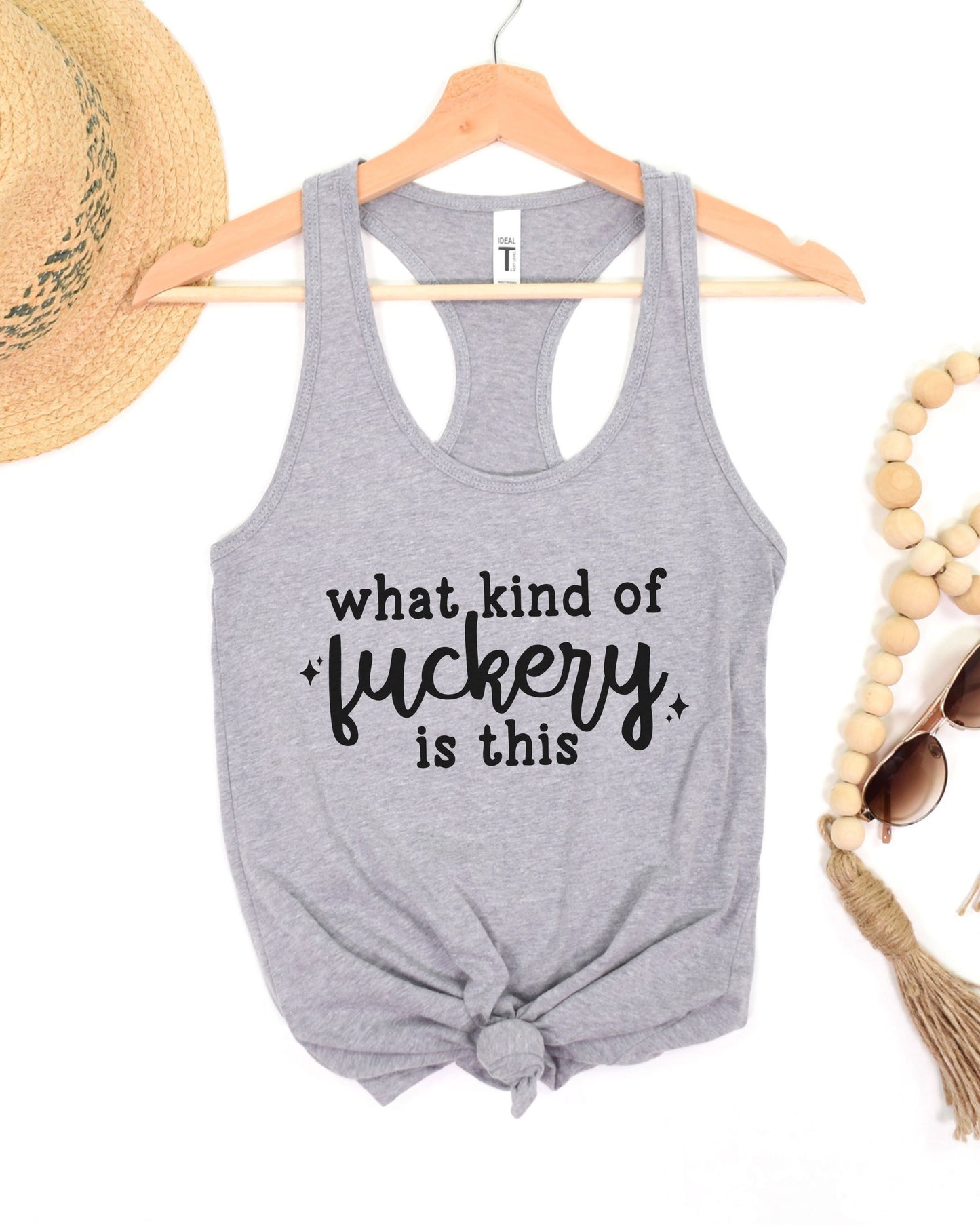 Gray tank top with text on a hanger with accessories