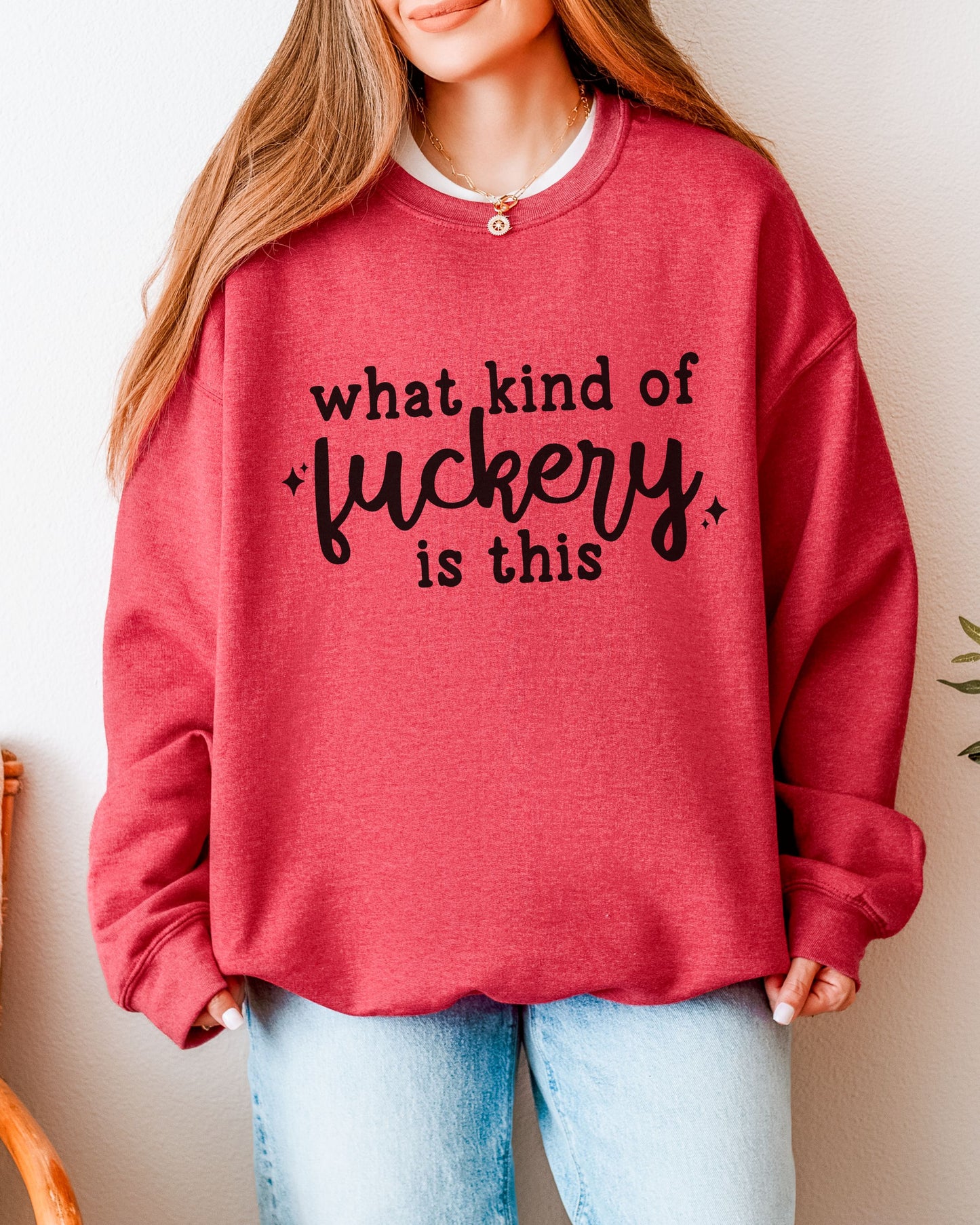 Person wearing a red sweatshirt with text, standing against a neutral background