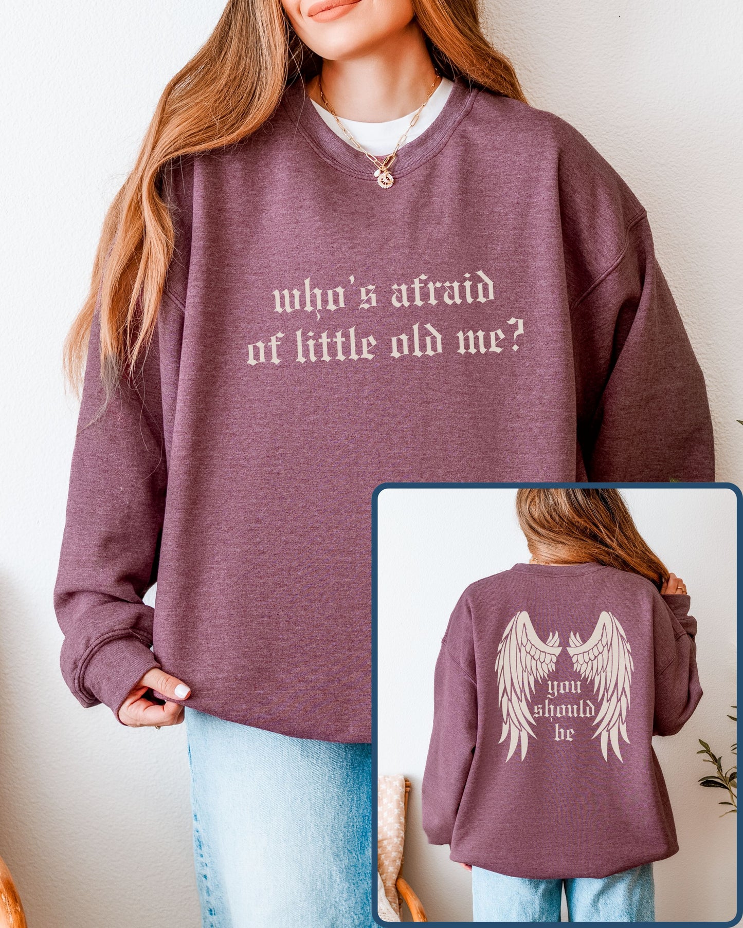 Person wearing a maroon sweatshirt with text on front and back, against a plain background.