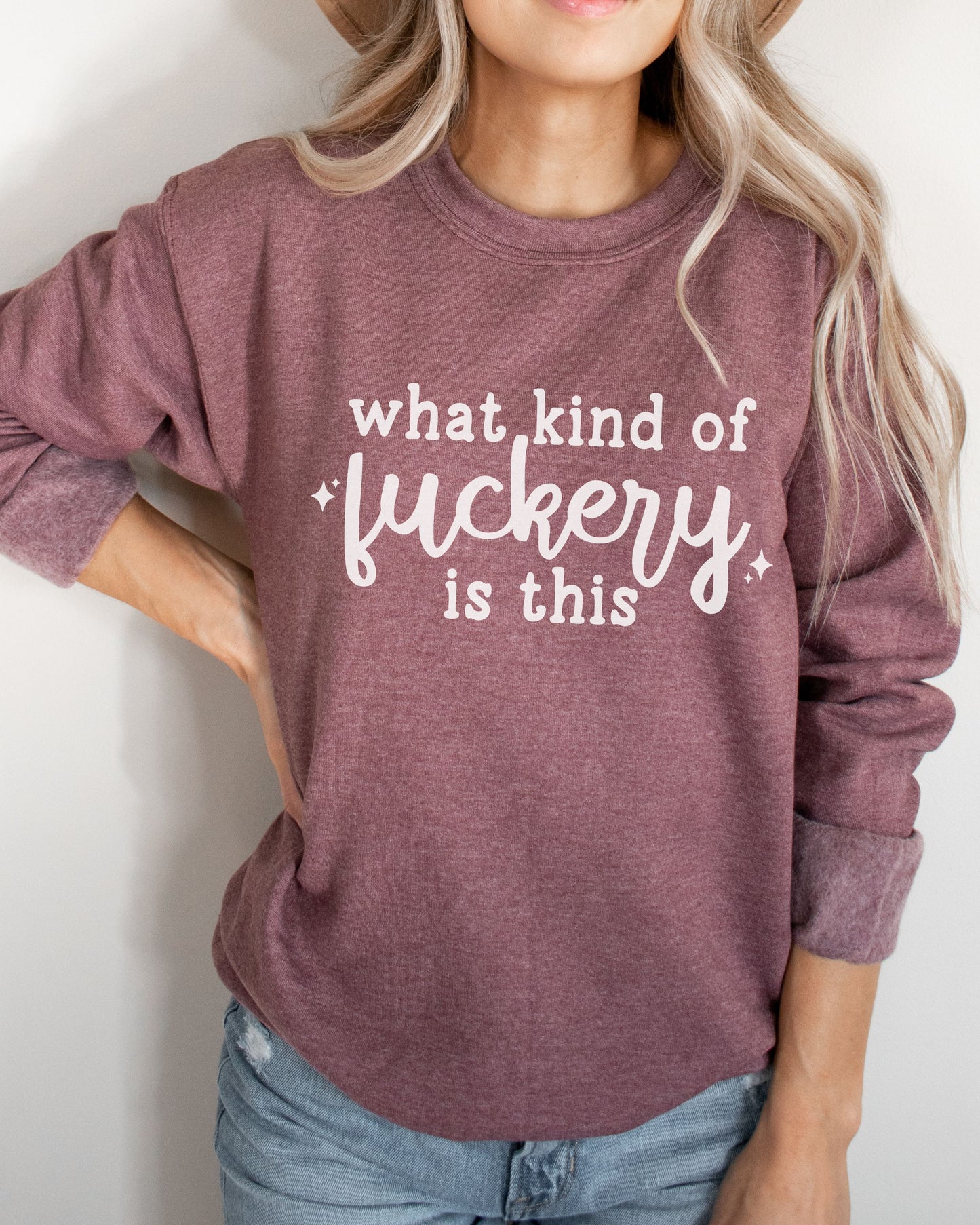 Person wearing a maroon sweatshirt with text on a plain background