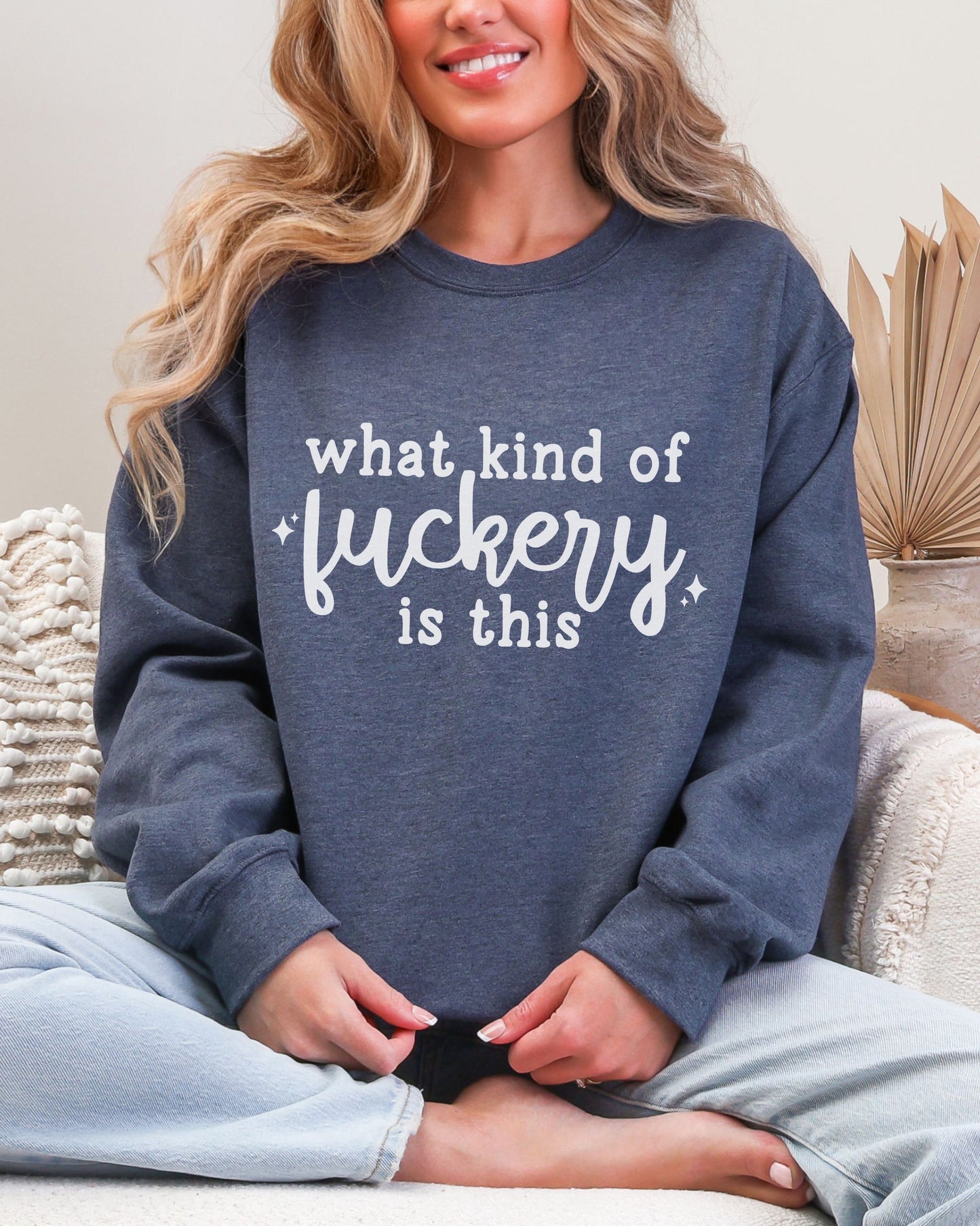 Person wearing a navy sweatshirt with white text sitting on a couch.