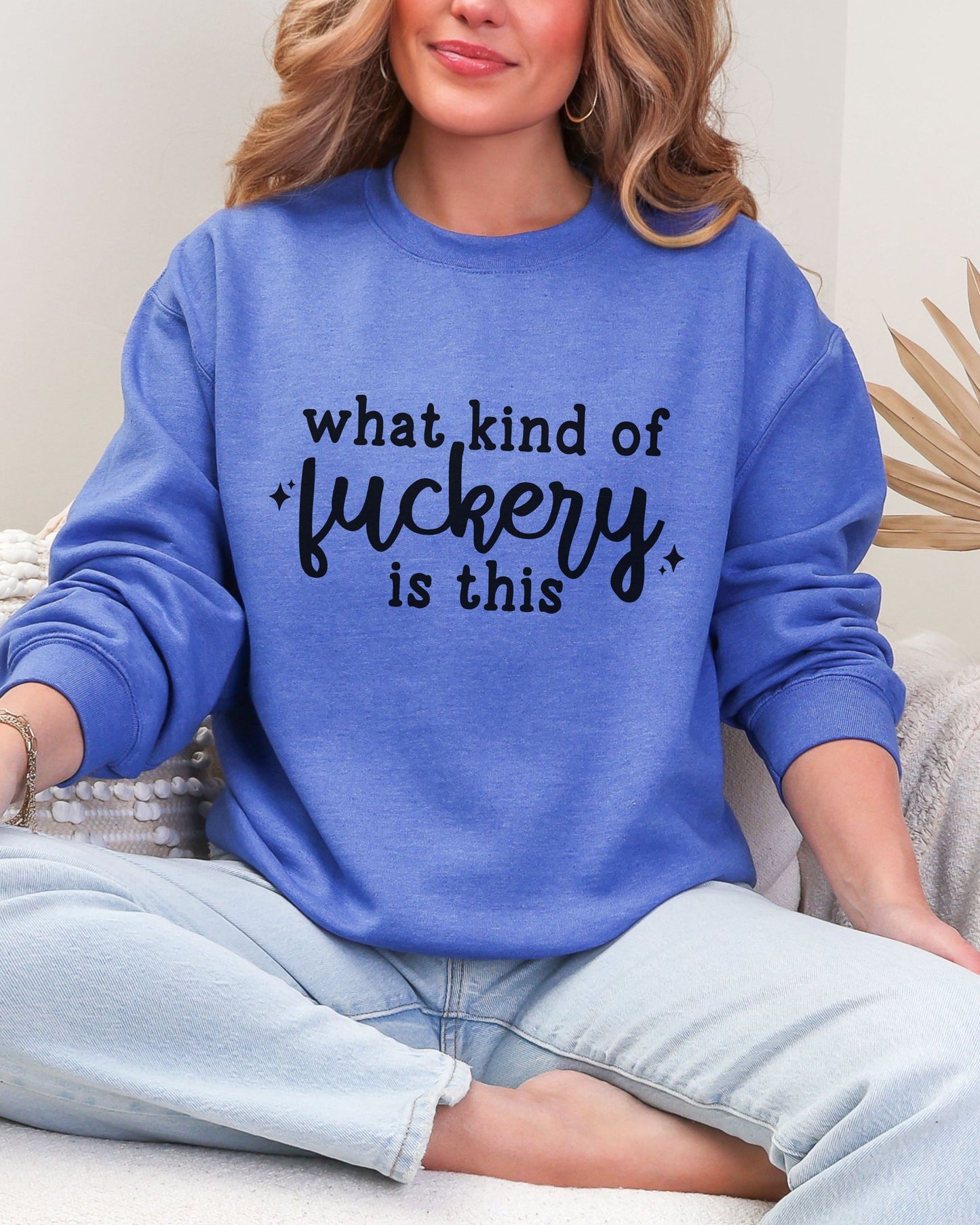 Person wearing a blue sweatshirt with text sitting on a couch.