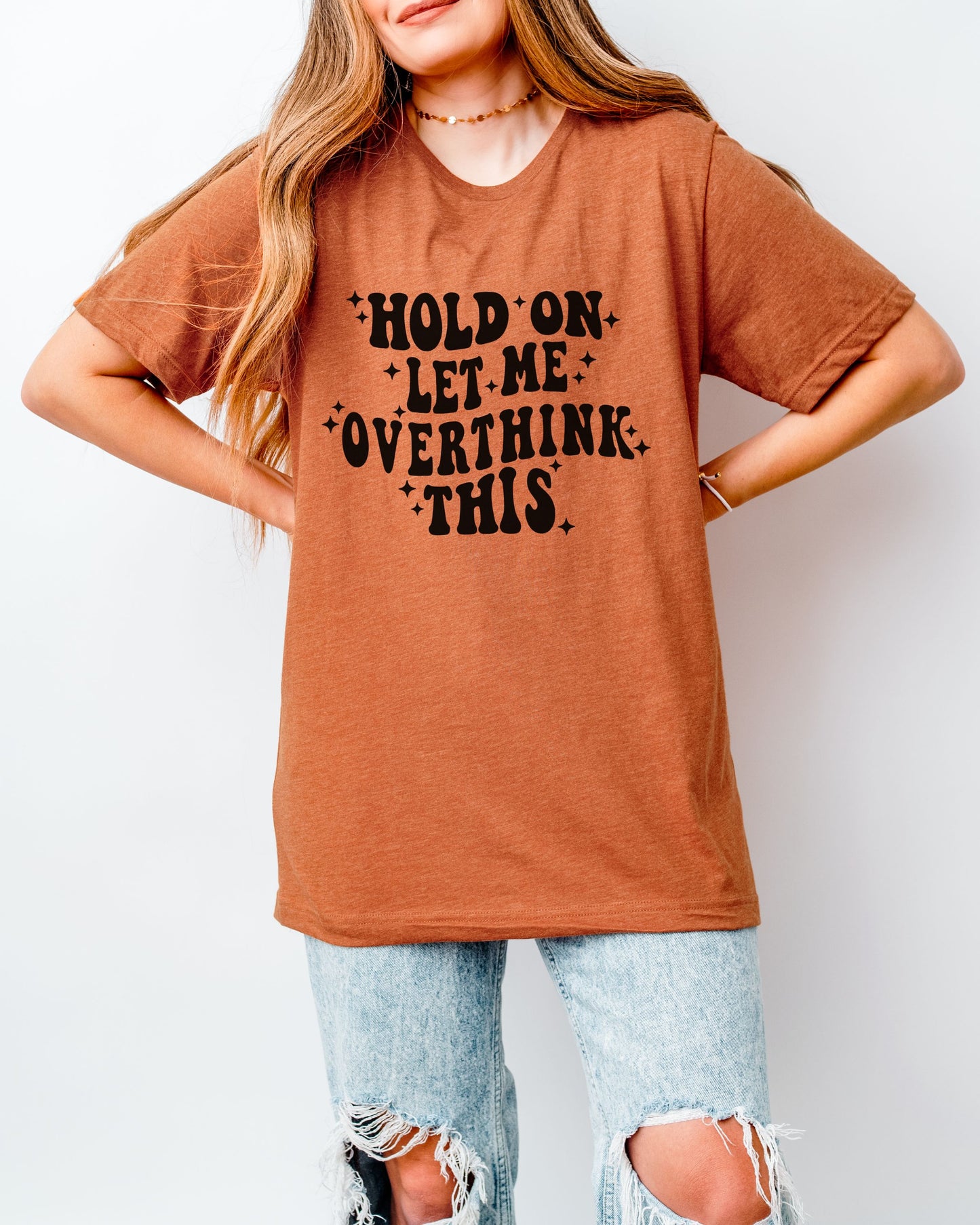 Person wearing a orange t-shirt with text on a plain background
