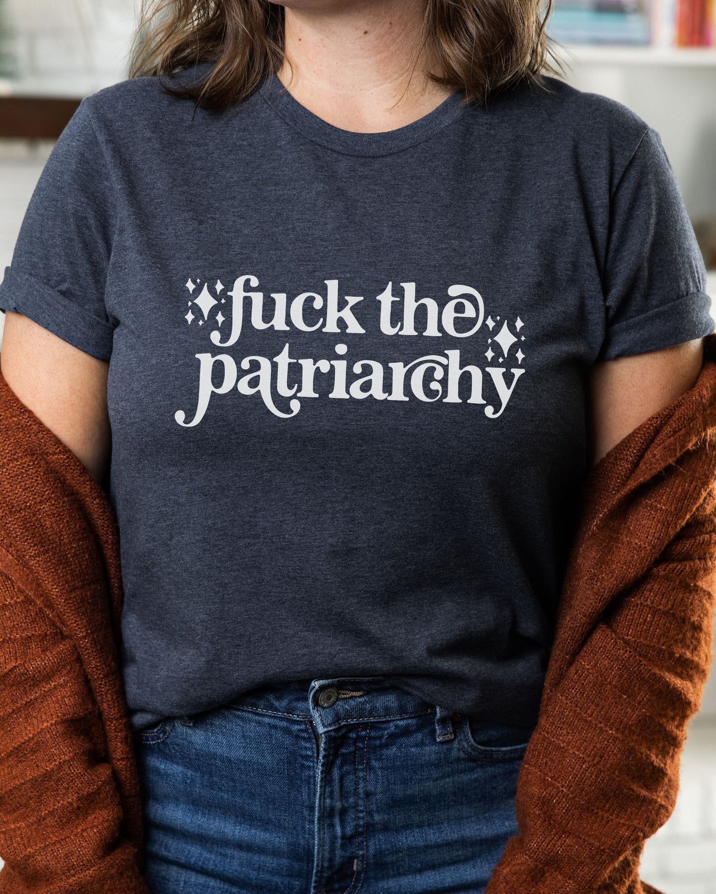 woman wearing a heather navy fuck the patriarchy shirt, feminist graphic tee