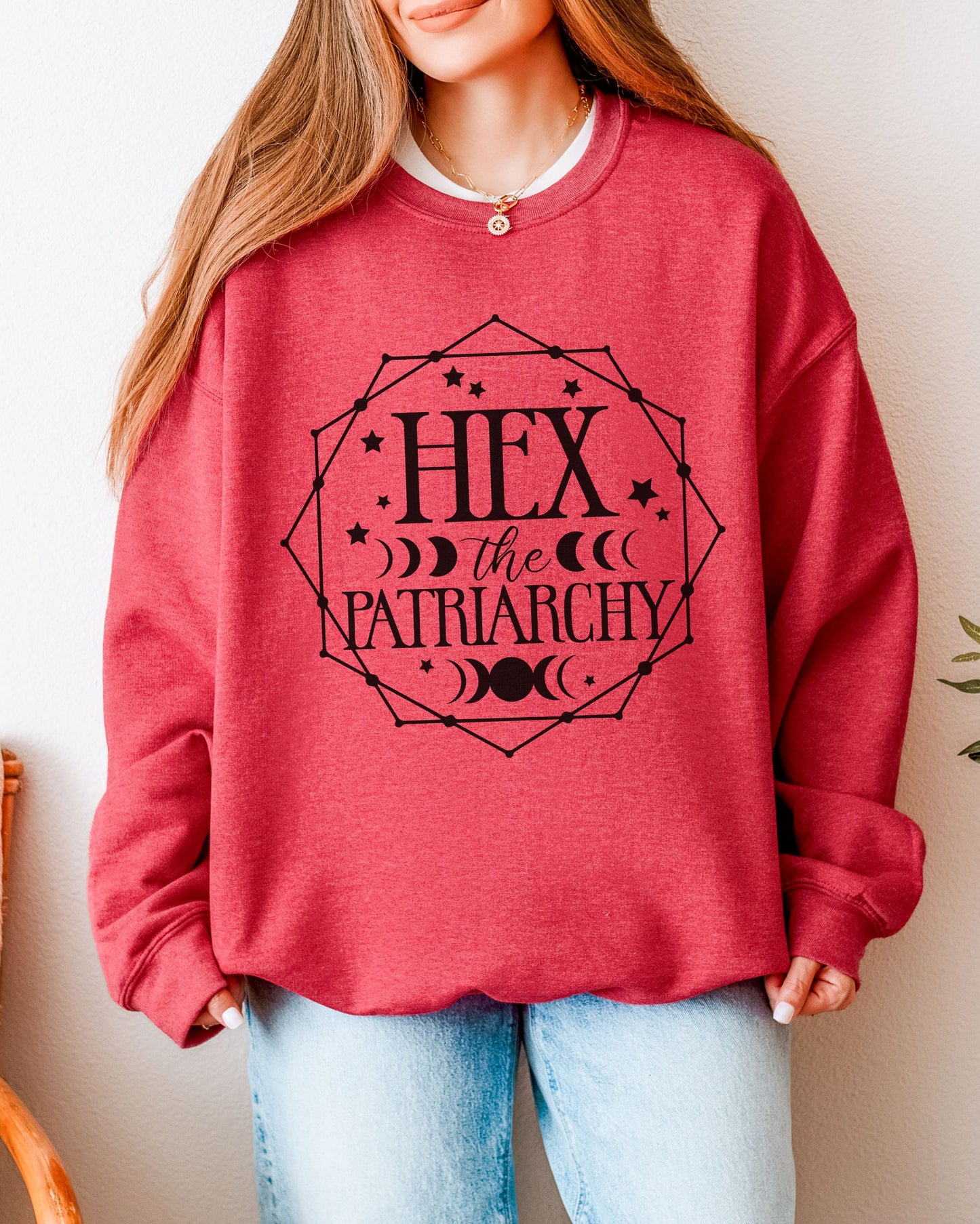 Person wearing a red sweatshirt with 'Hex the Patriarchy' text