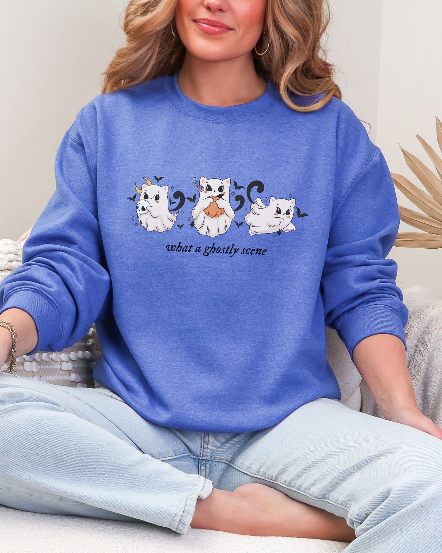 Person wearing a blue sweatshirt with ghost illustrations and text.
