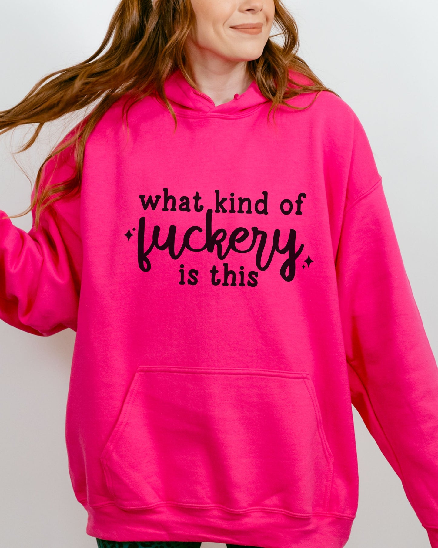 Person wearing a bright pink hoodie with text on a plain background
