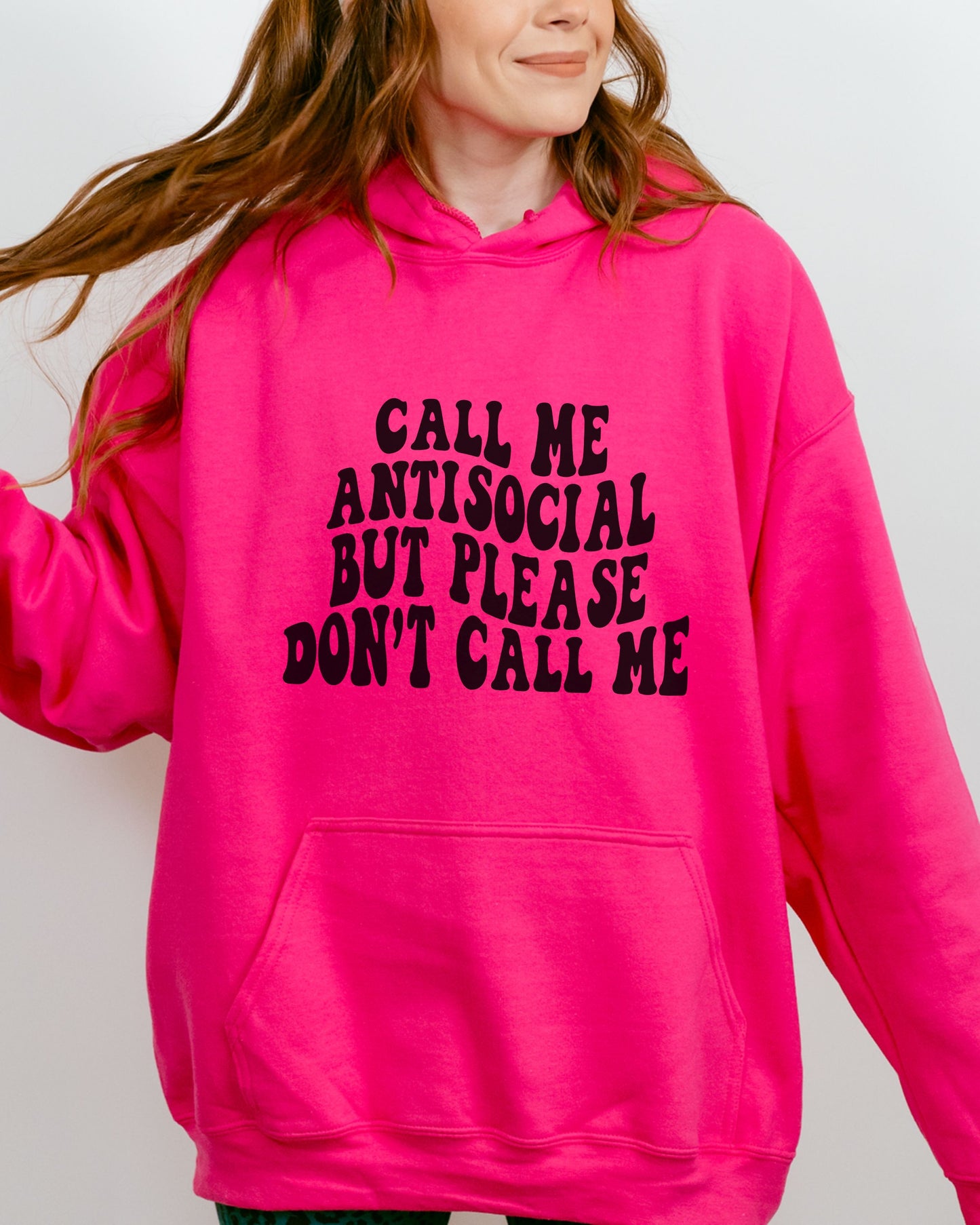 Person wearing a bright pink hoodie with text on a plain background