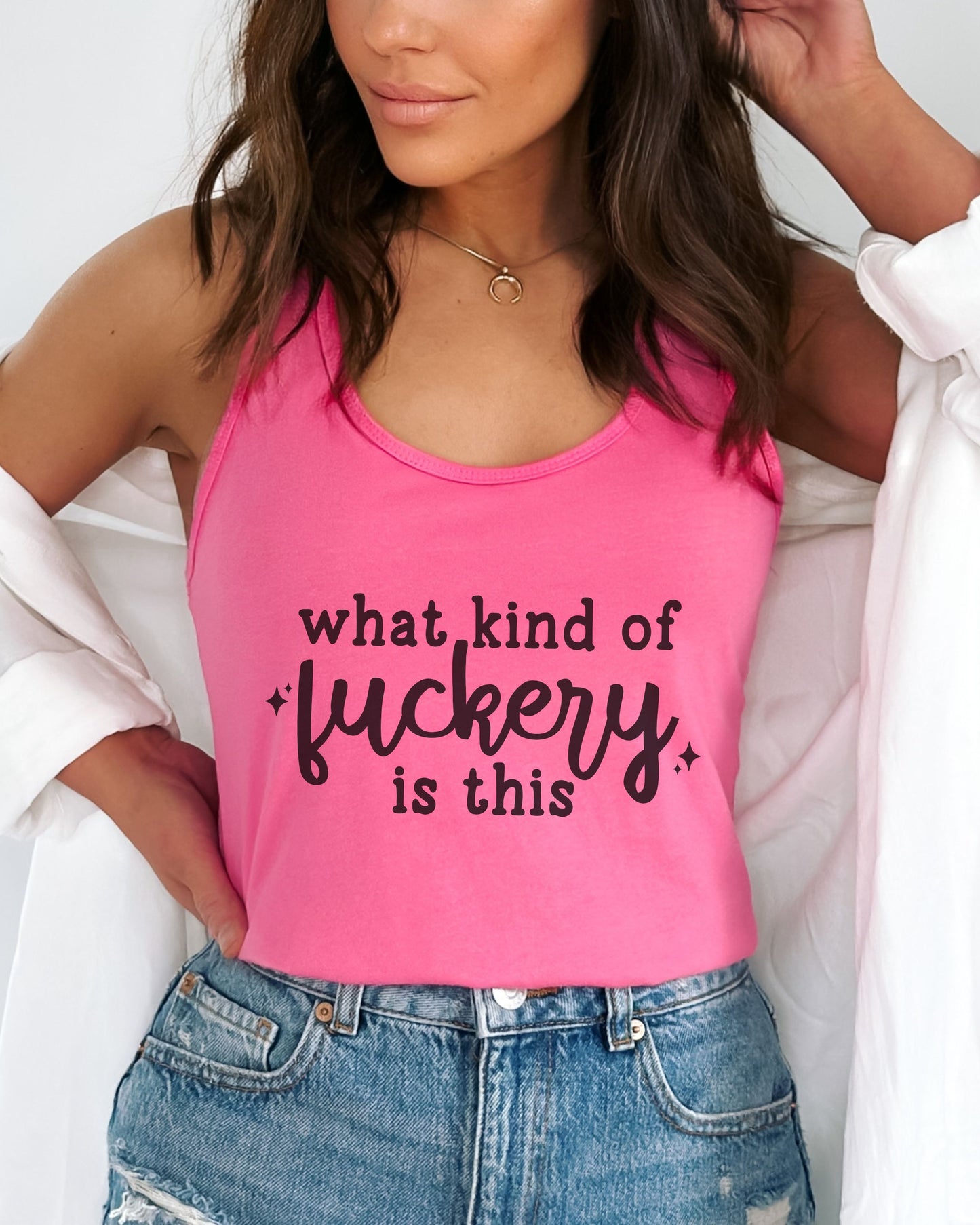 Person wearing a pink tank top with text, standing against a neutral background