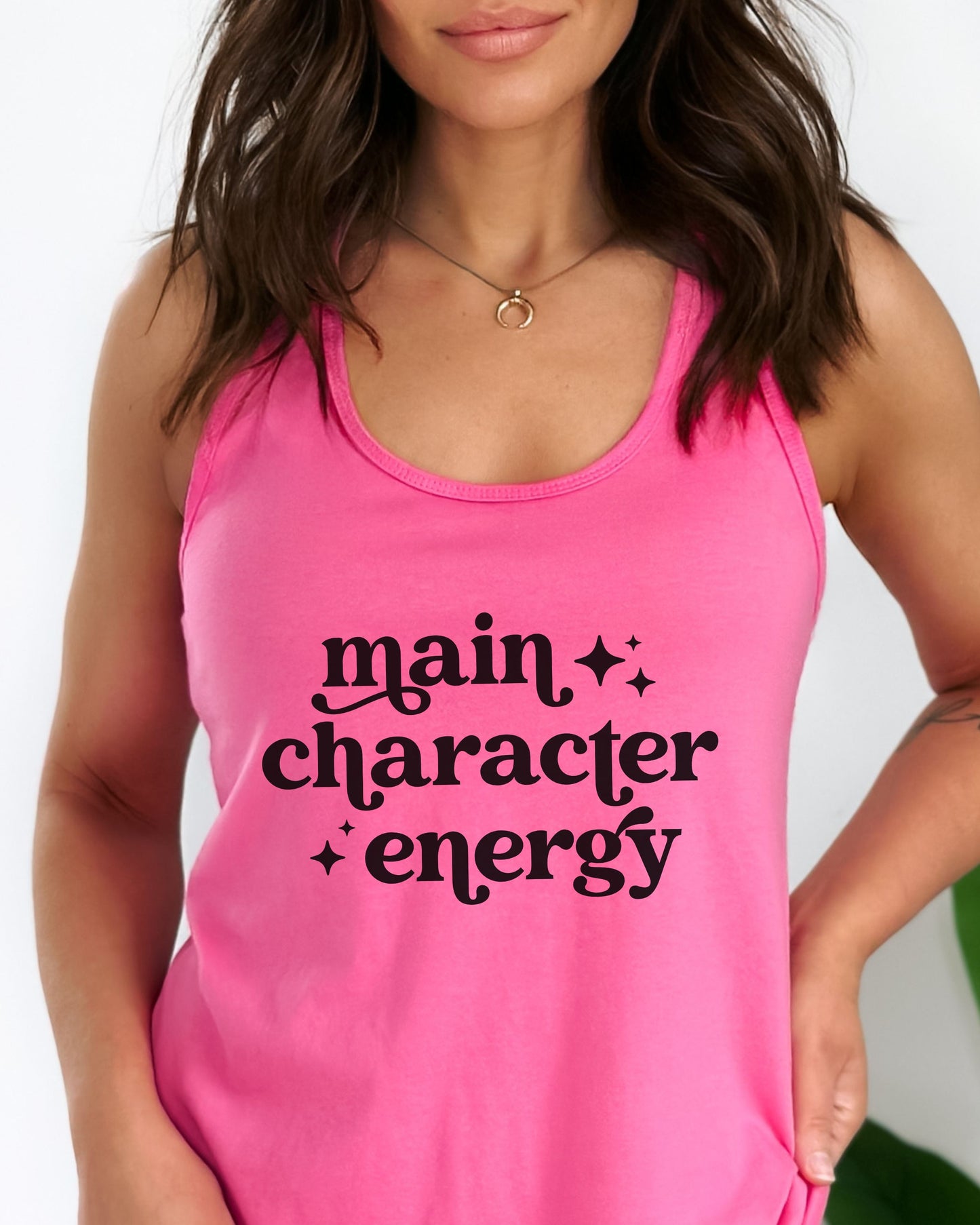 Person wearing a pink tank top with 'main character energy' text.