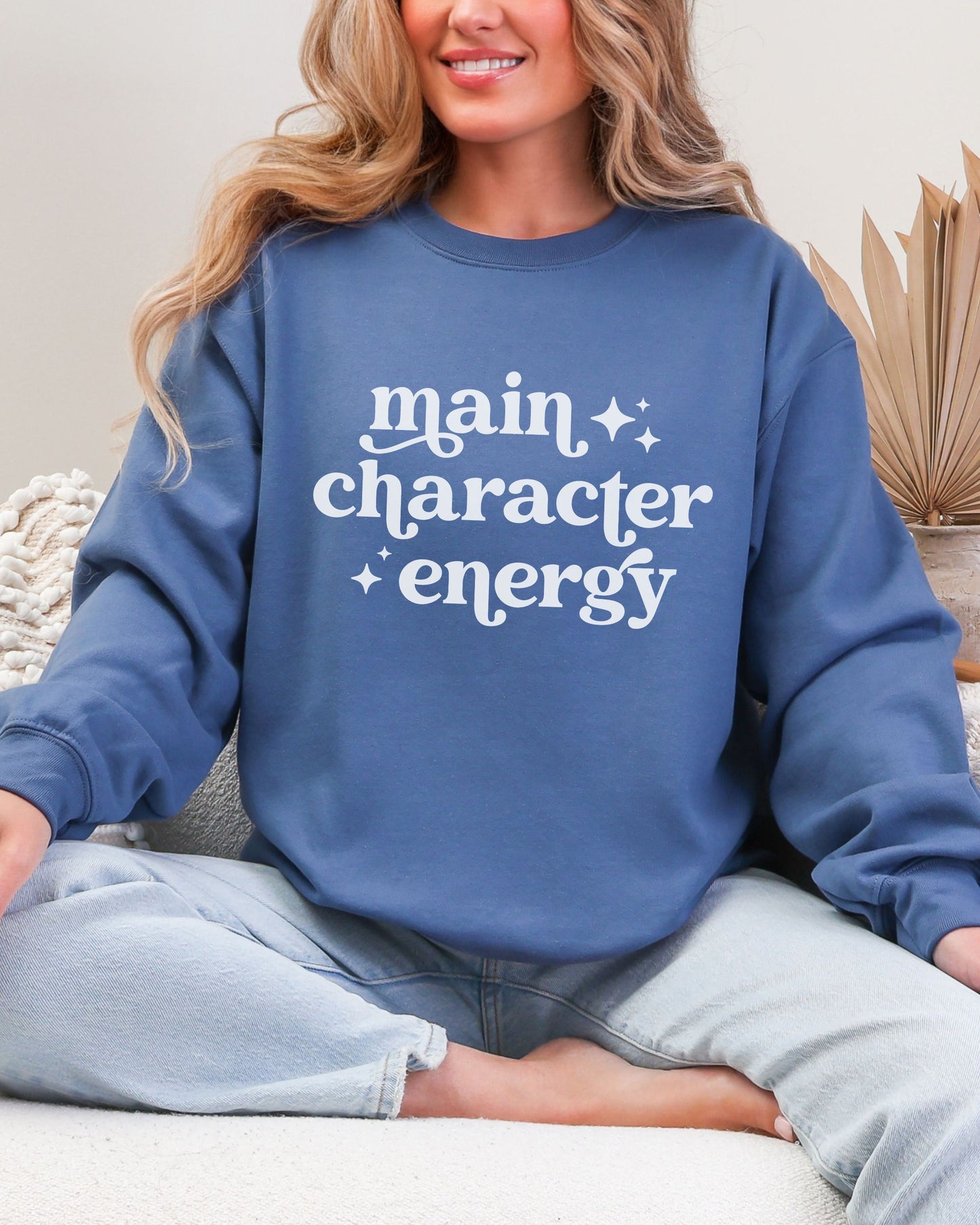 Person wearing a blue sweatshirt with 'main character energy' text.