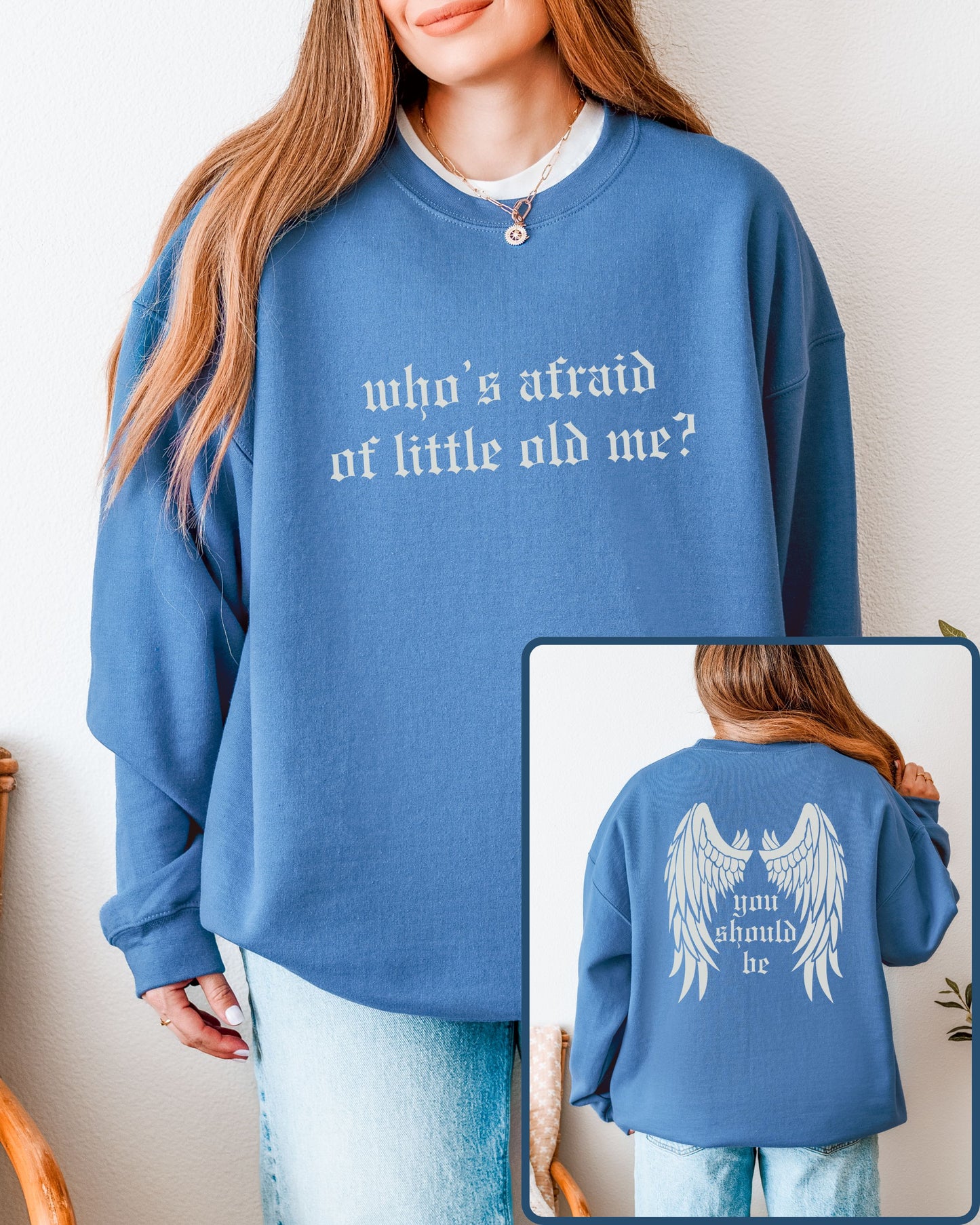 Blue sweatshirt with text 'who's afraid of little old me?' worn by a person, with a close-up of the back showing 'you should be'.