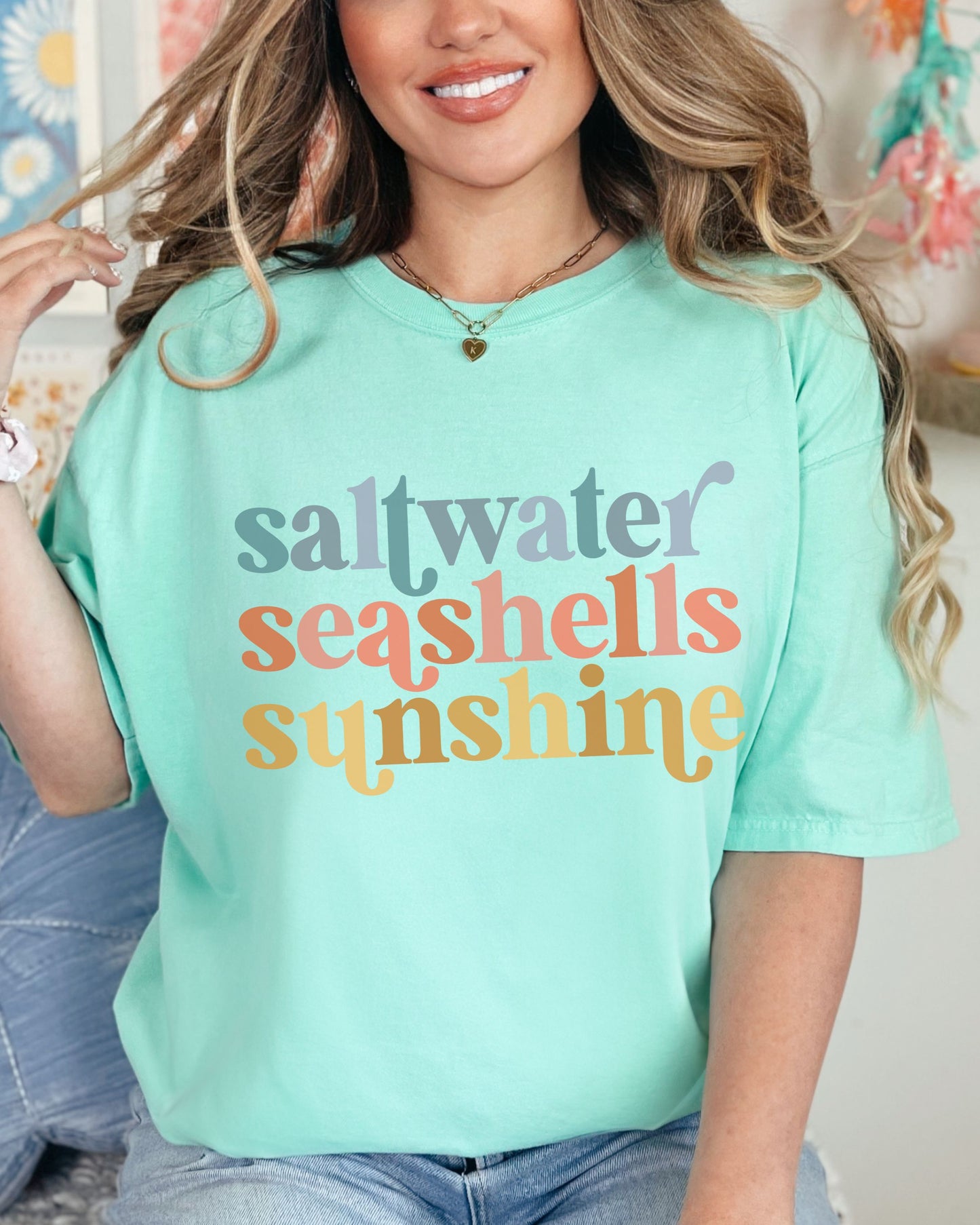 woman wearing beach vibes shirt with saltwater seashells sunshine design