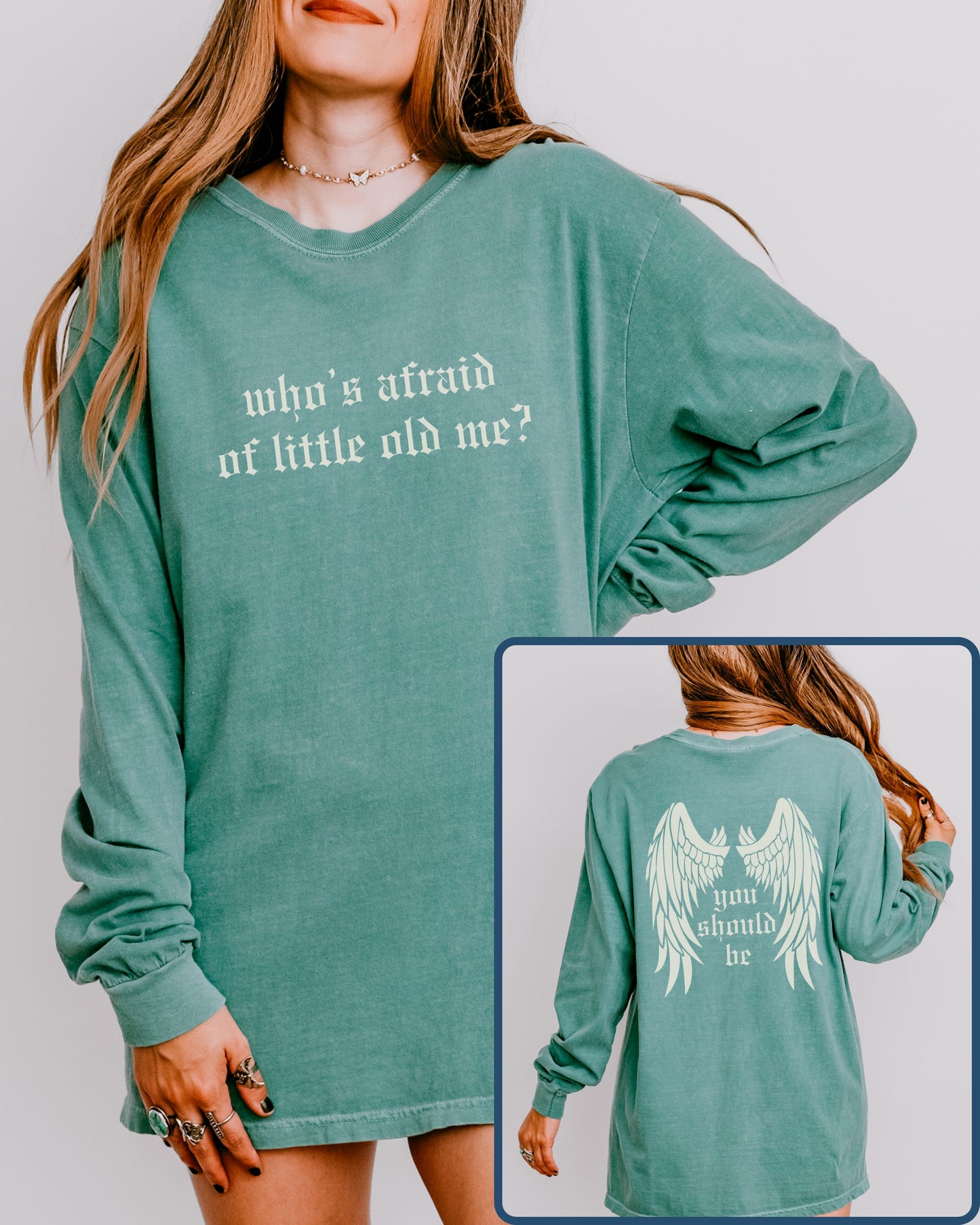 Green long-sleeve shirt with text and wings graphic worn by a person, on a plain background.
