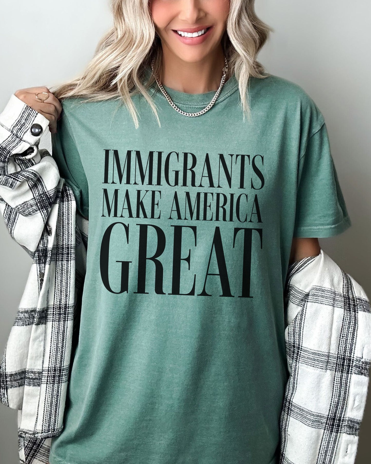 Person wearing a green t-shirt with 'IMMIGRANTS MAKE AMERICA GREAT' text.