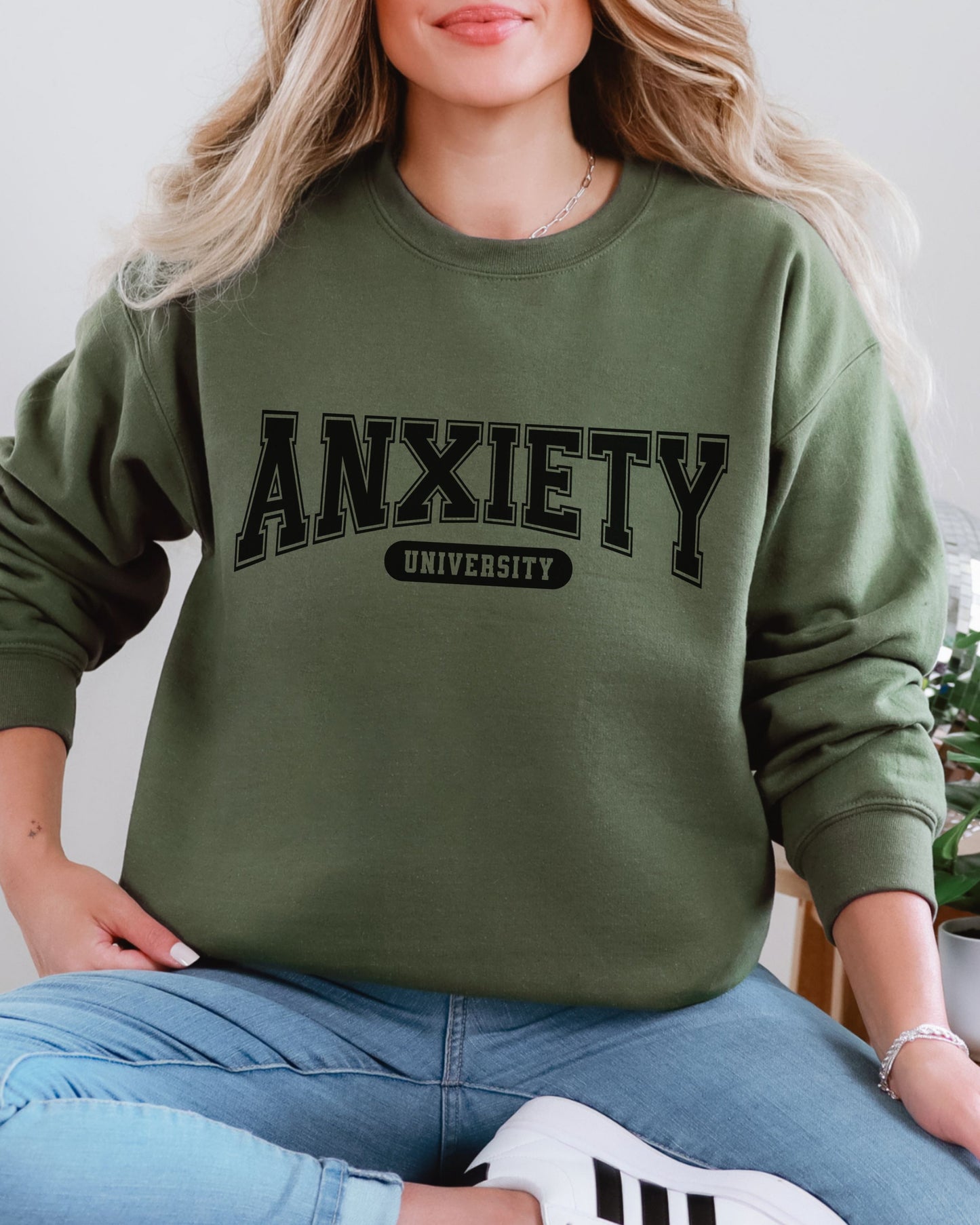 Person wearing a green sweatshirt with 'ANXIETY UNIVERSITY' text.